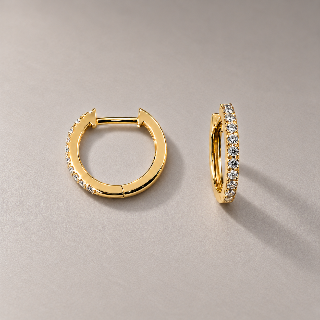 Yellow gold diamond hoops on warm grey.png