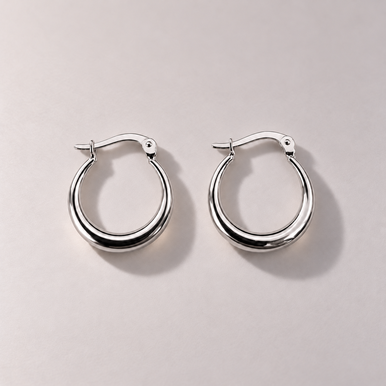 Polished white gold graduated hoop earrings.png