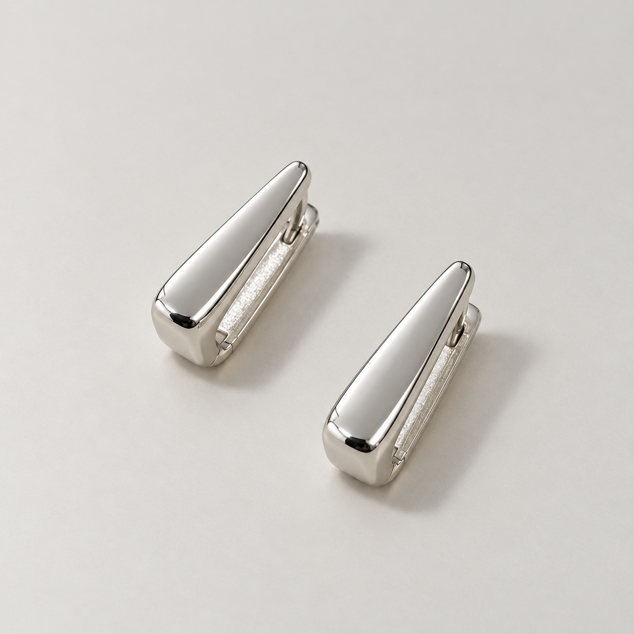 Polished white gold tapered hoop earrings.png