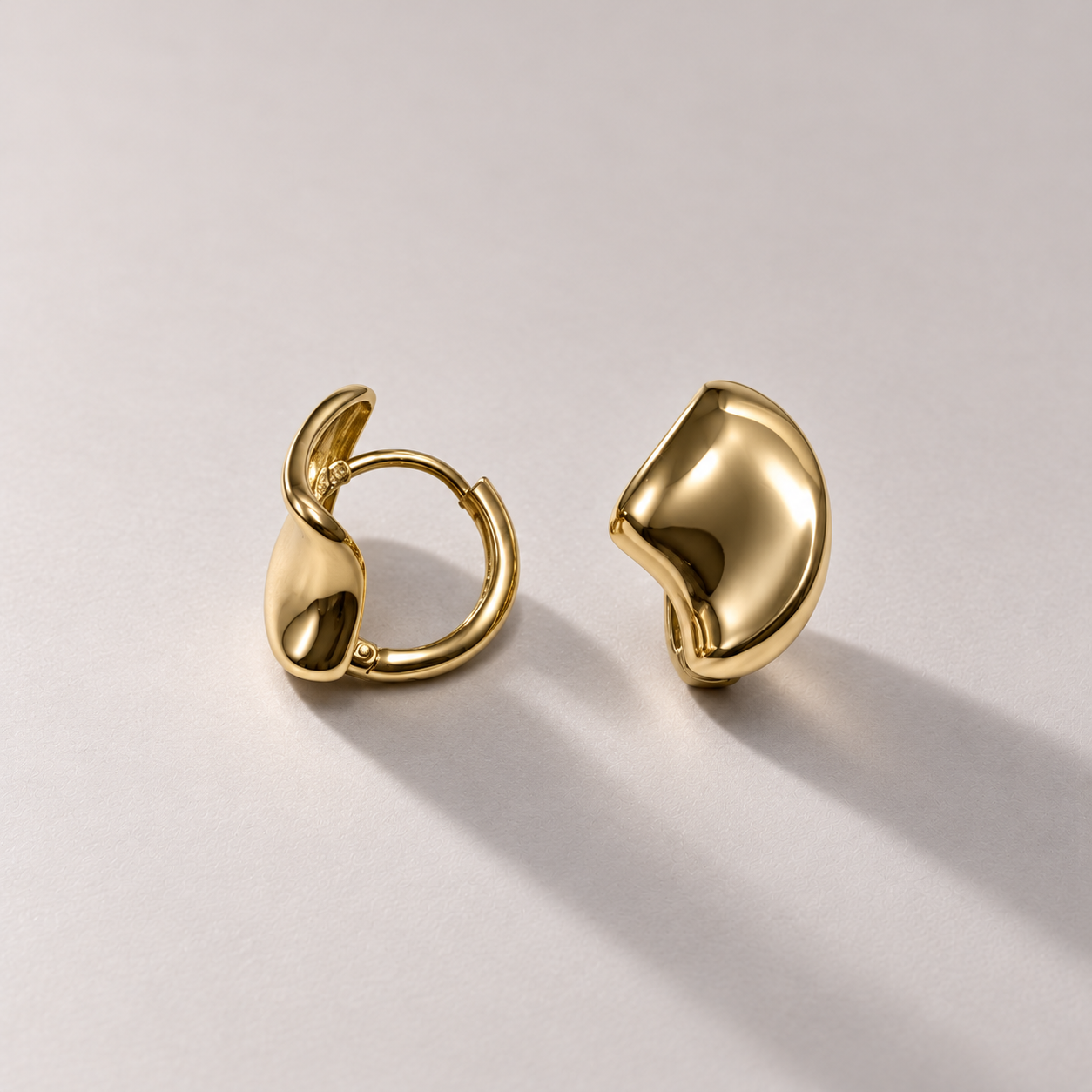 Sculptural yellow gold earrings on warm gray-4.png