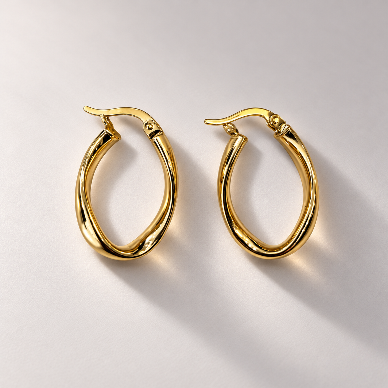 Twisted gold oval hoop earrings-2.png