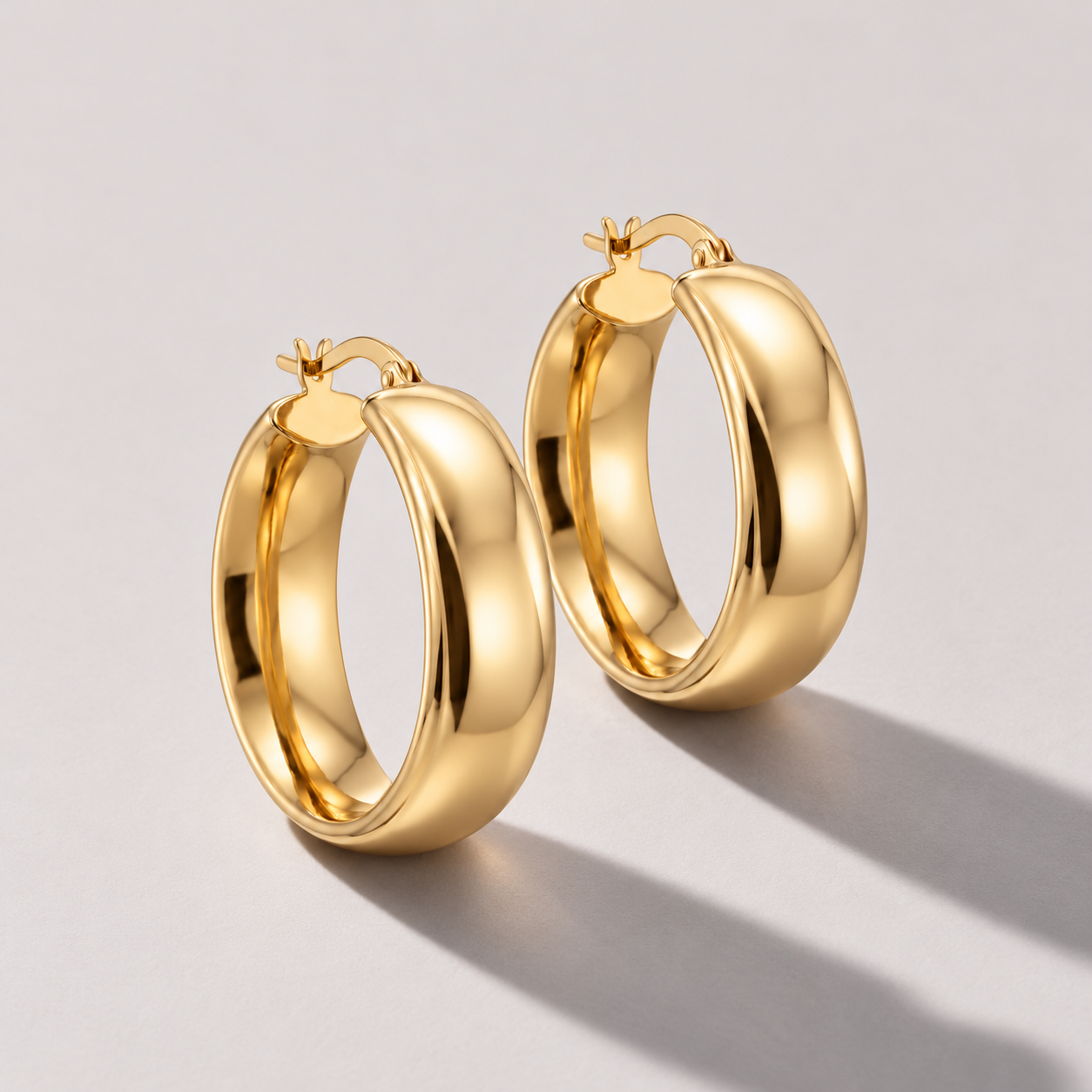 Polished yellow gold hoop earrings.png