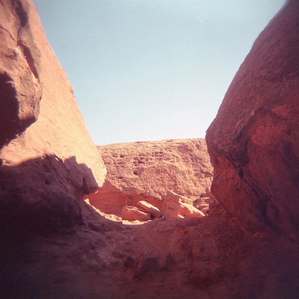 View of a sunlit red rock canyon with clear sky