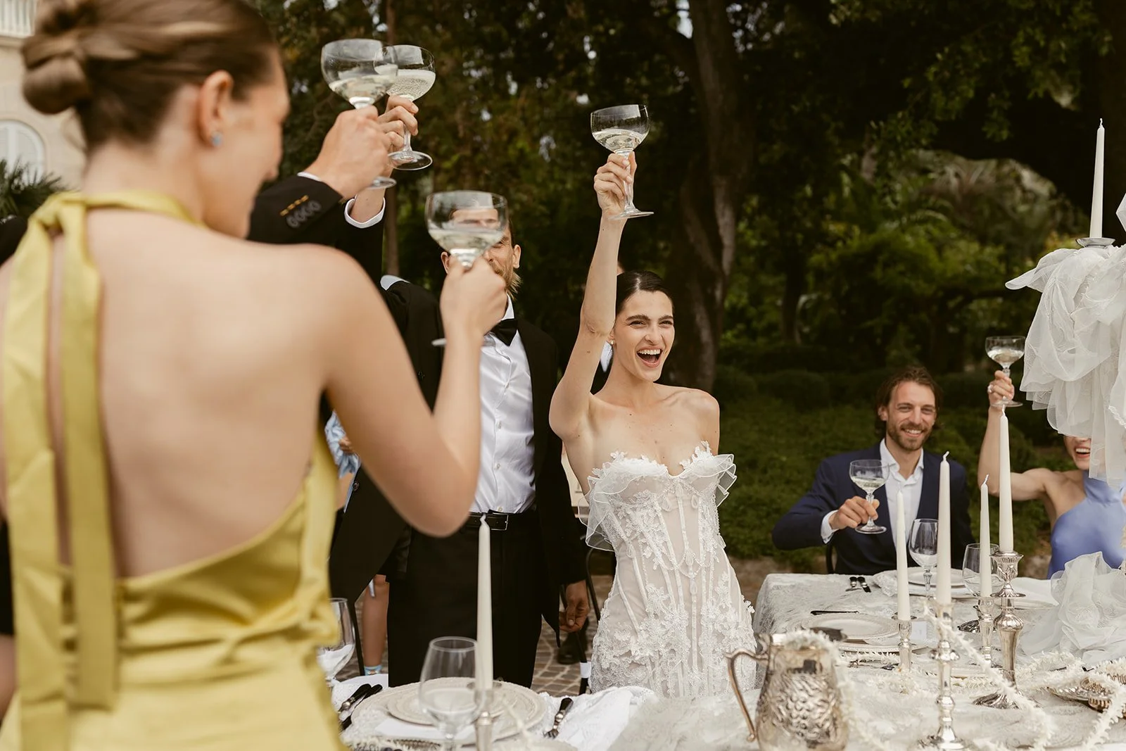 Bride and groom joyfully toast with their wedding guests