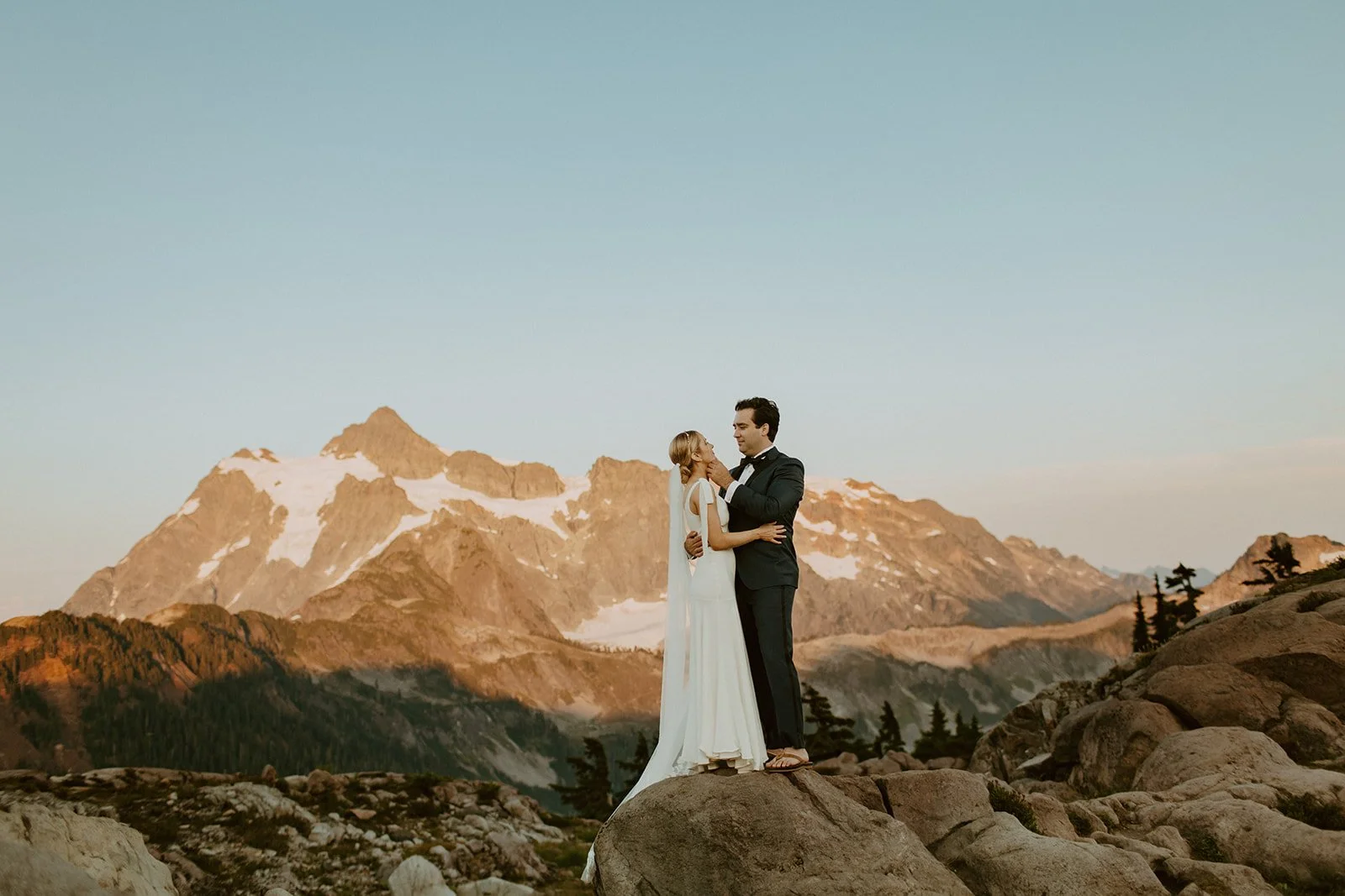 Bride and groom stand close at Artist Point at sunset