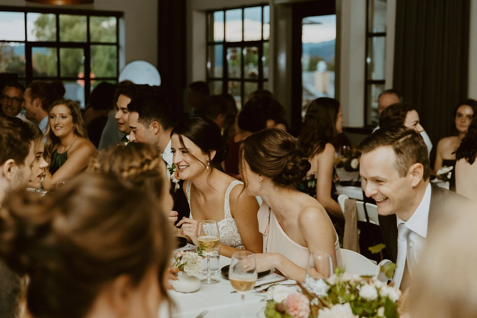 Bride and groom sit with all of their guests for dinner at Matia Restaurant on Orcas Island