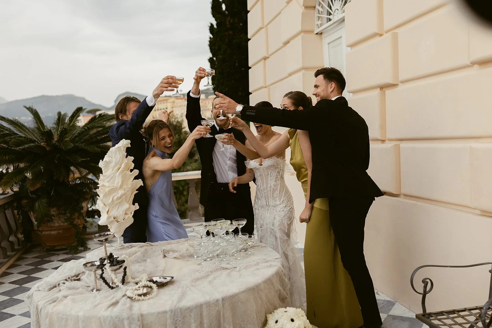 Bride and groom joyfully toast with their guests during their Italian wedding reception at Villa Astor
