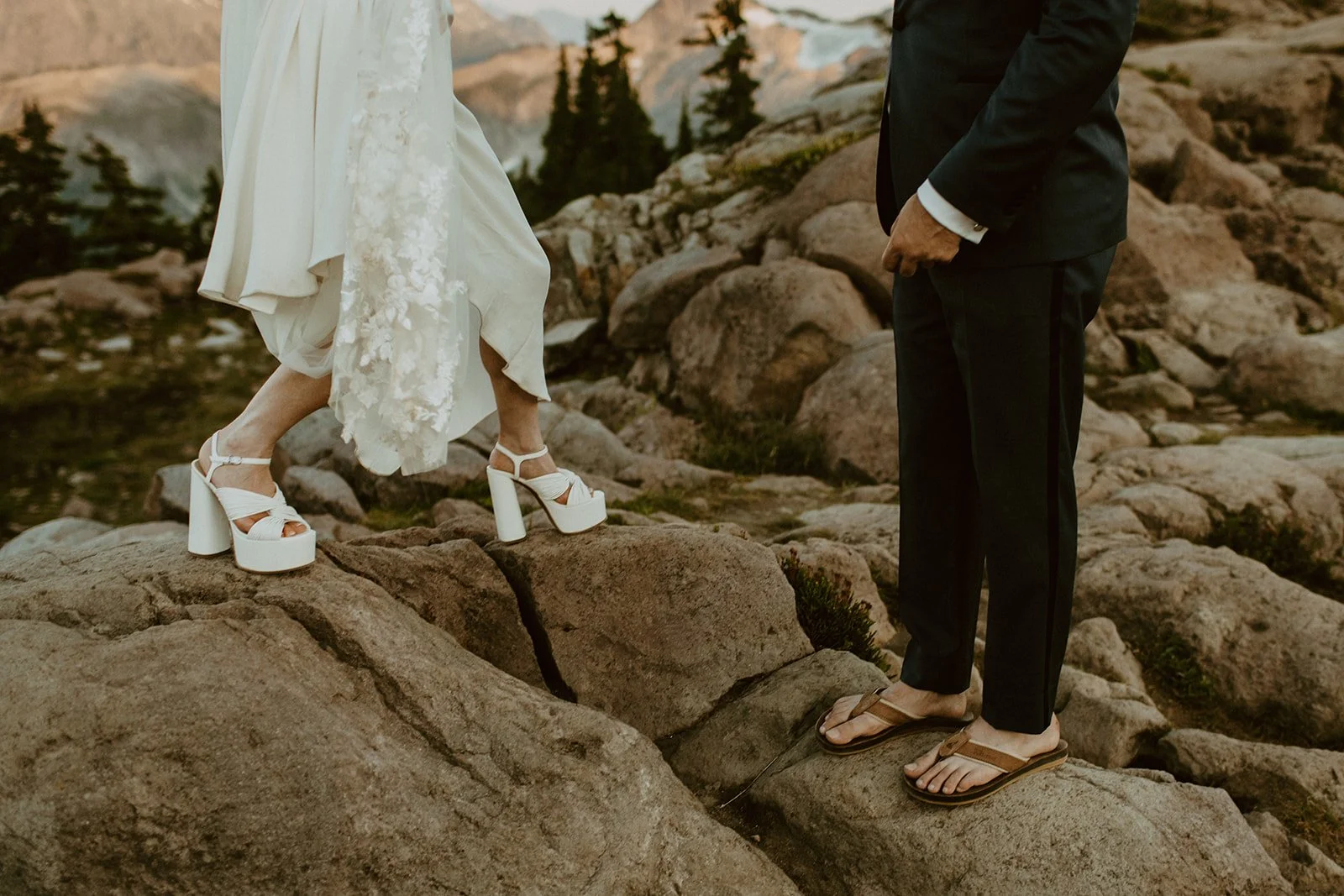 A close up of bride and groom's shoes as they walk across boulders in the North Cascades