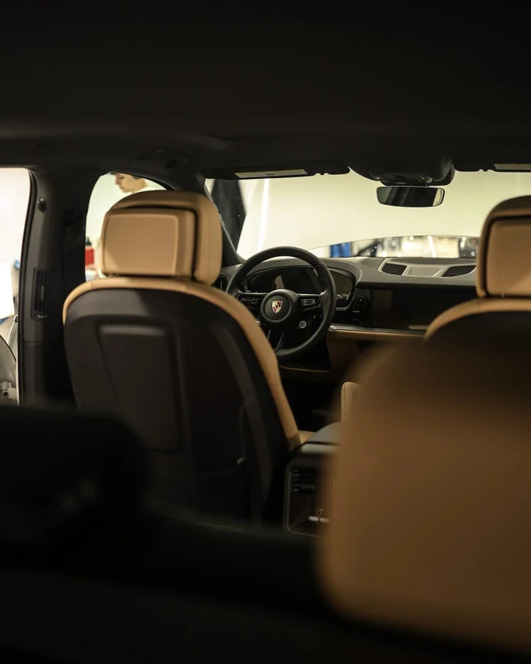 Tan leather interior of a Porsche photographed from the rear seat after a full interior detail at Ascension Automotive