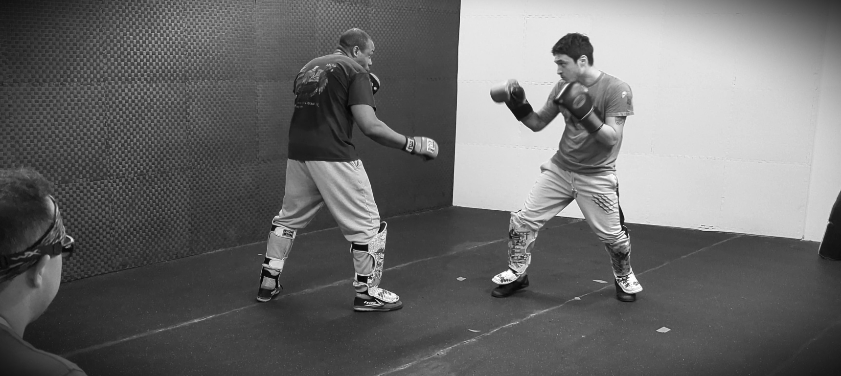 two men in jeet kune do class boxing, a black and white filter