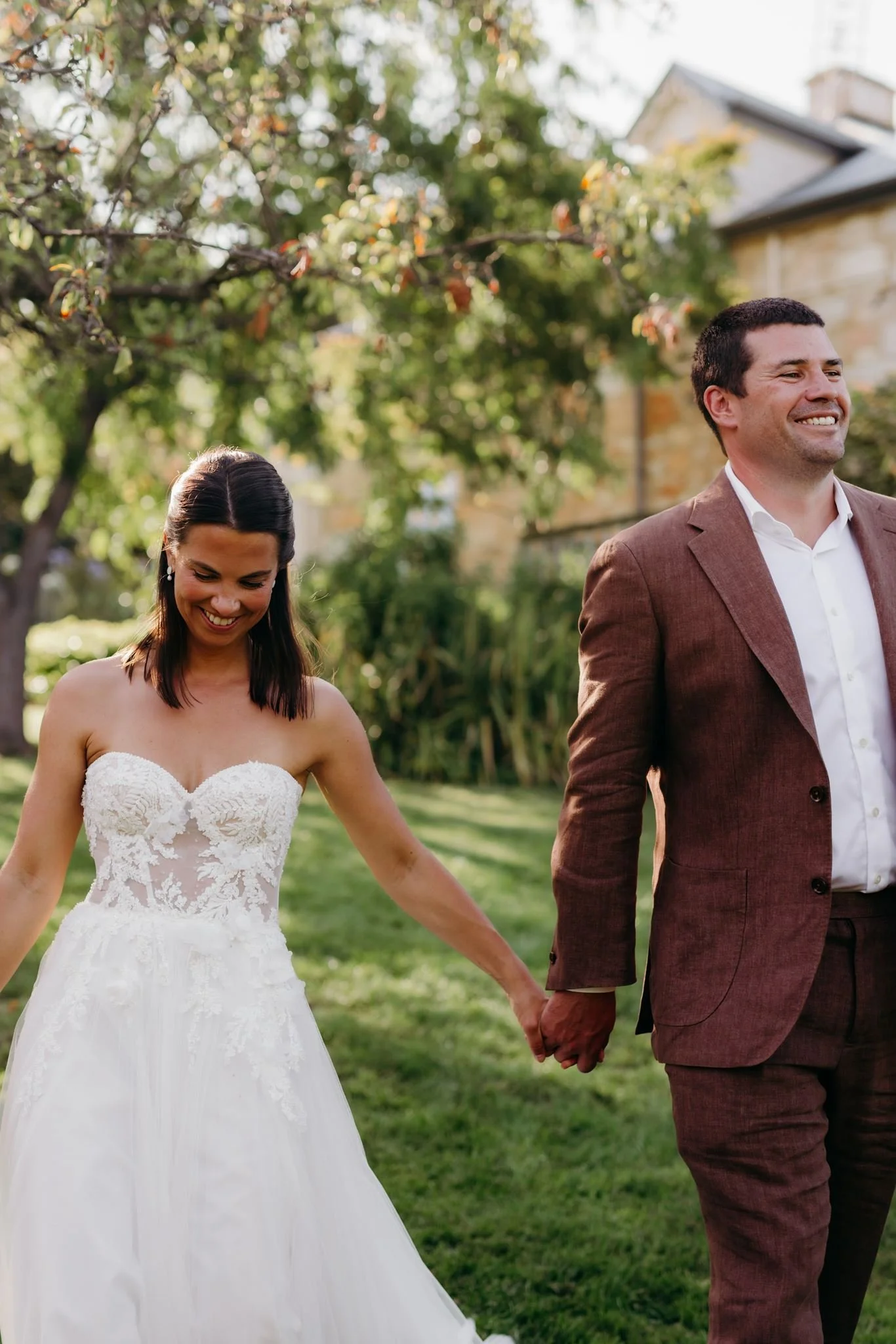 a wedded couple walking outside in the sunny vineyard