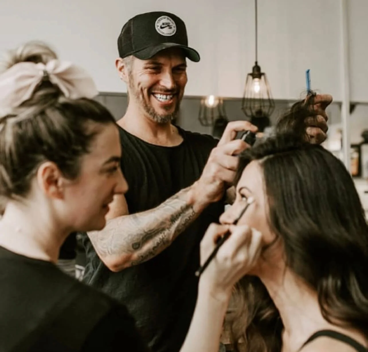 hair stylist and makeup artist preparing bride