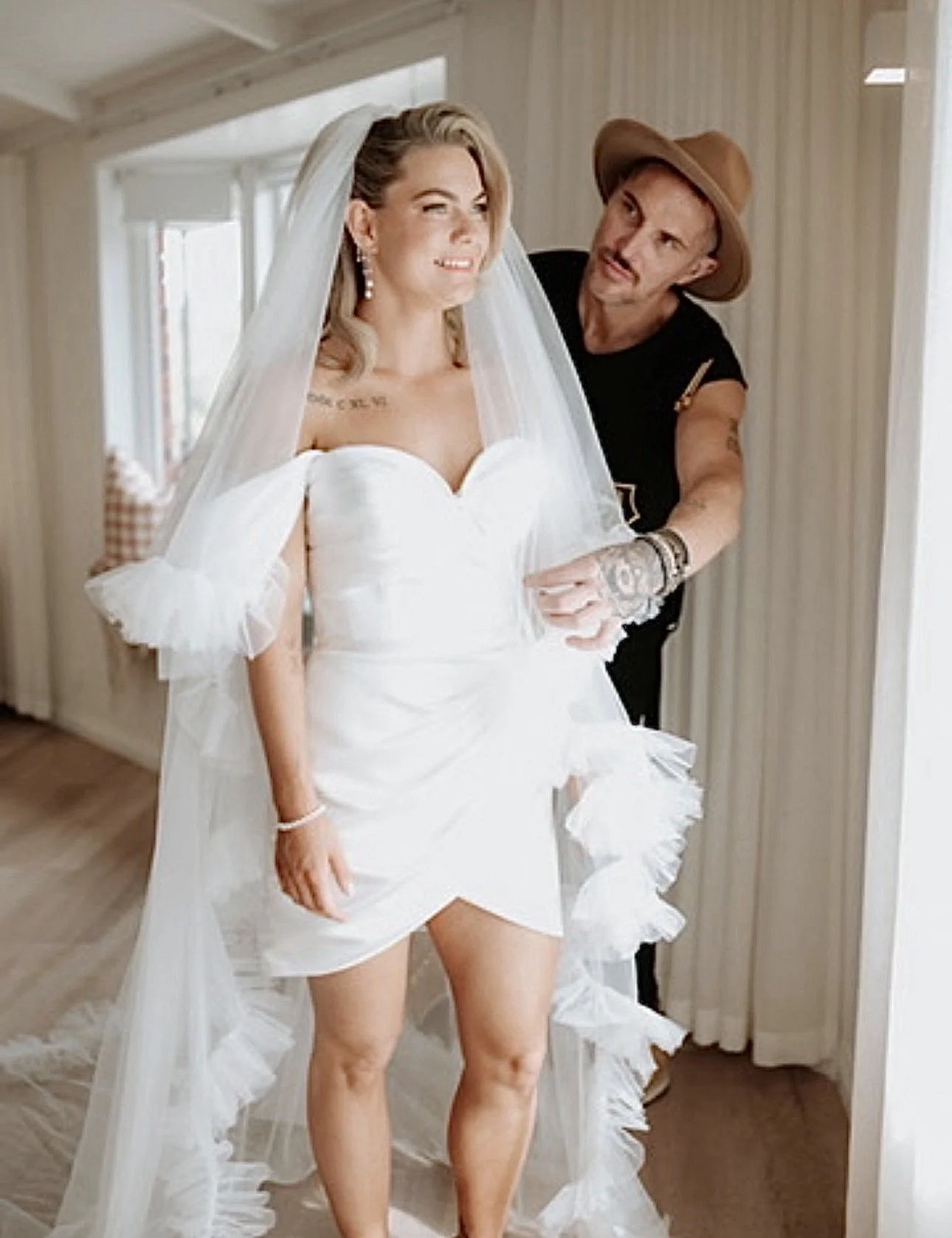 Ben O'Brien, Tasmanian wedding hairstylist, adjusting a bride's ruffled tulle veil while she gets ready