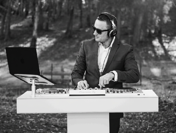 a black and white image of a dj wearing a suit and shades