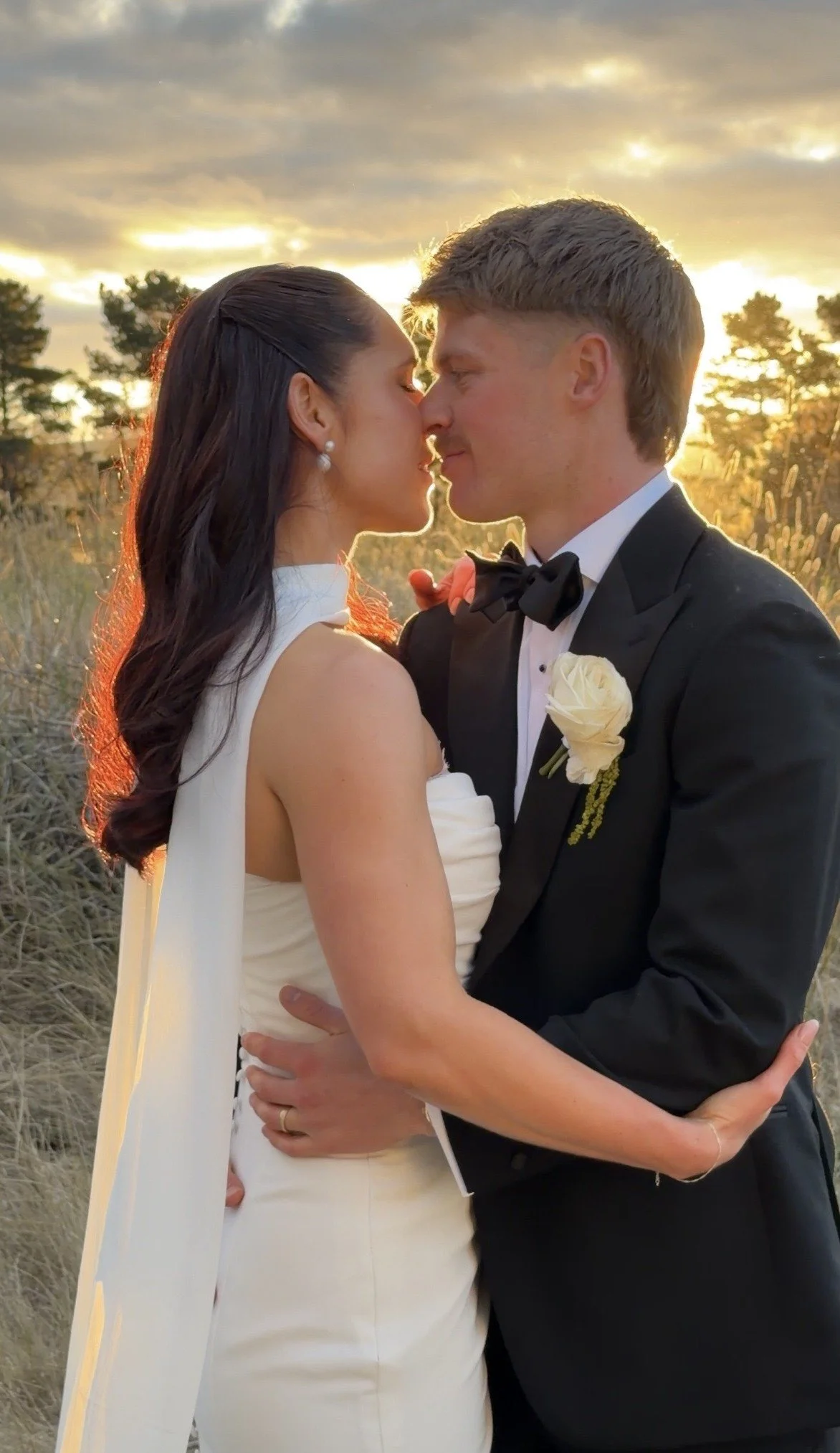 a wedded couple in front of sunset