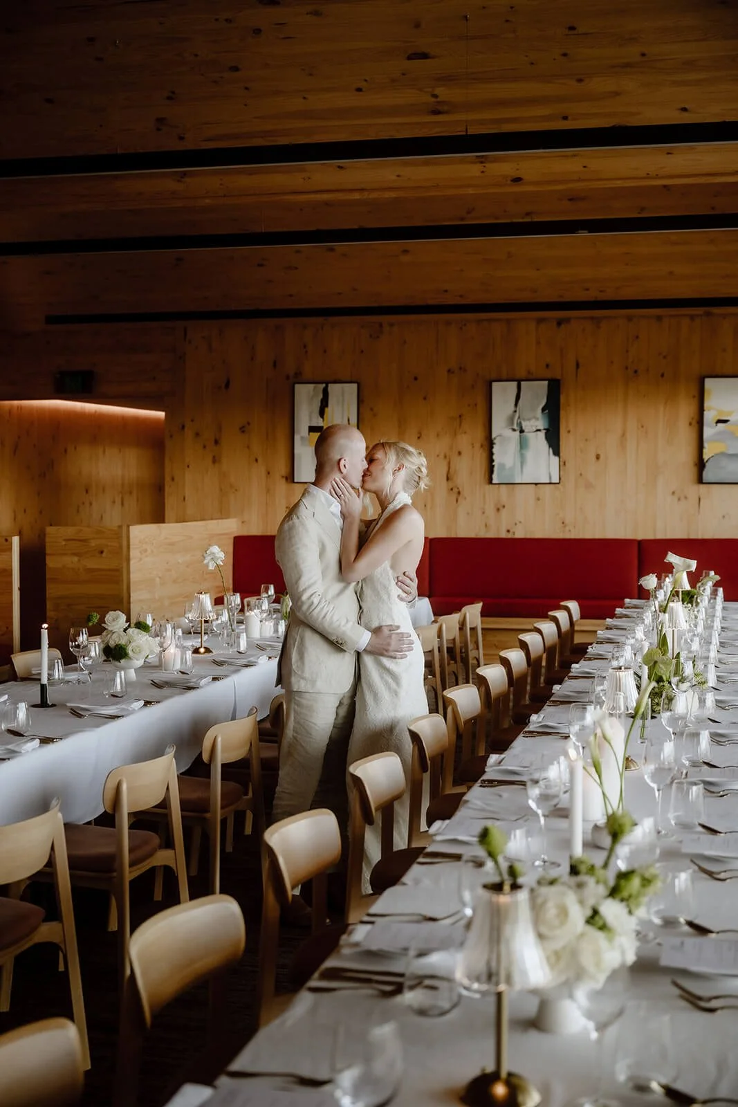 Bride and groom embracing beside long banquet tables set for a wedding reception at Iron Bay Creek Estate, timber-lined dining room