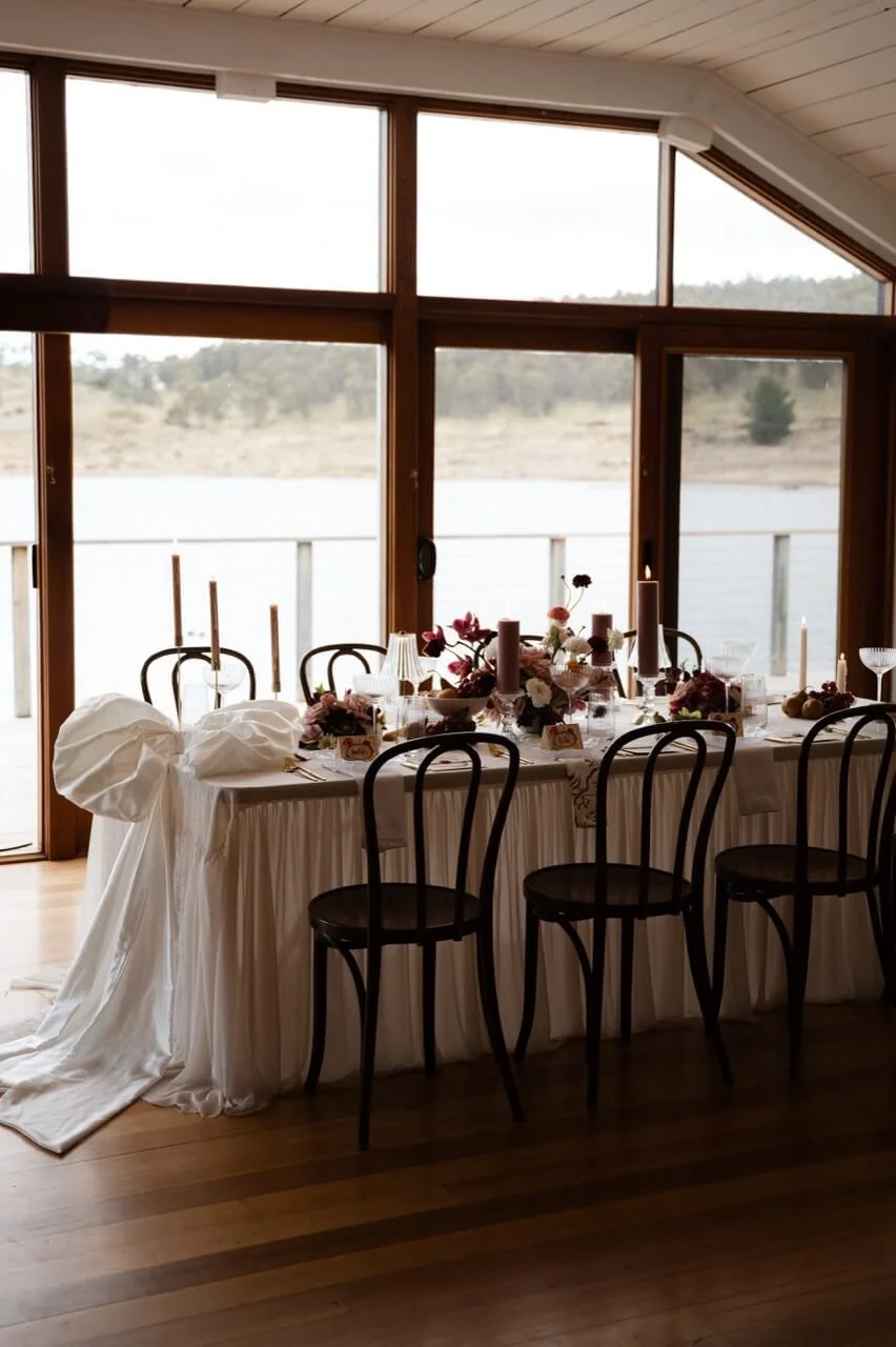 Intimate elopement dining table set with candles and dark florals overlooking the lake at Currawong Lakes, Lake Leake