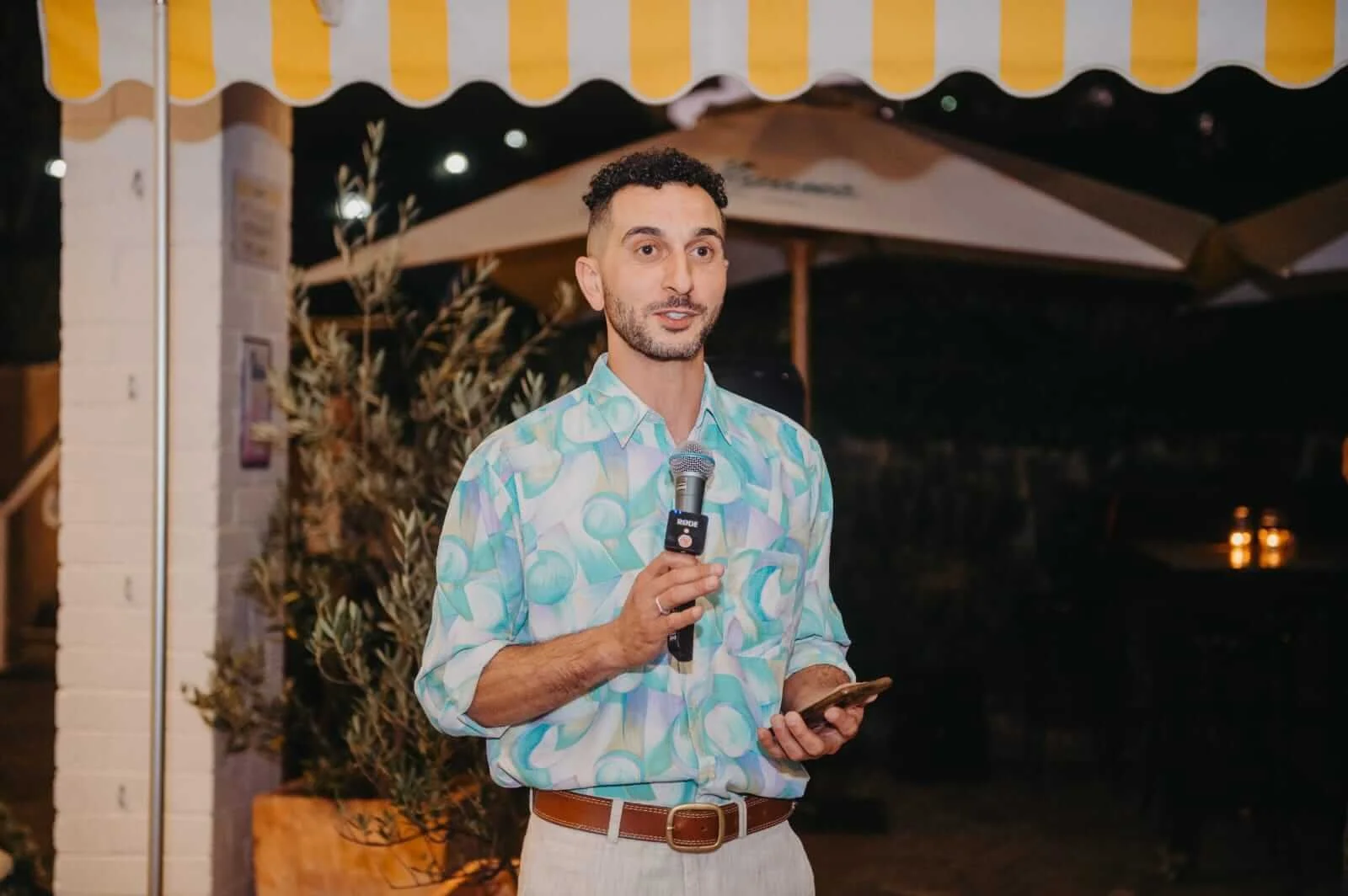 Andrew from Married by Andrew speaking into a microphone at a wedding event, Tasmanian celebrant
