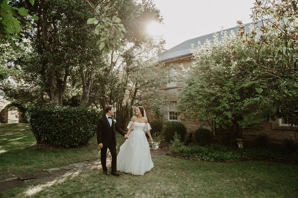bride and groom in golden hour in front of heritage stone building
