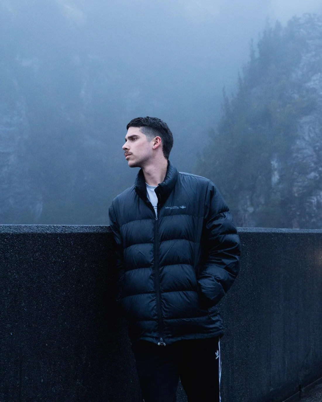 a man standing in dark puffy jacket