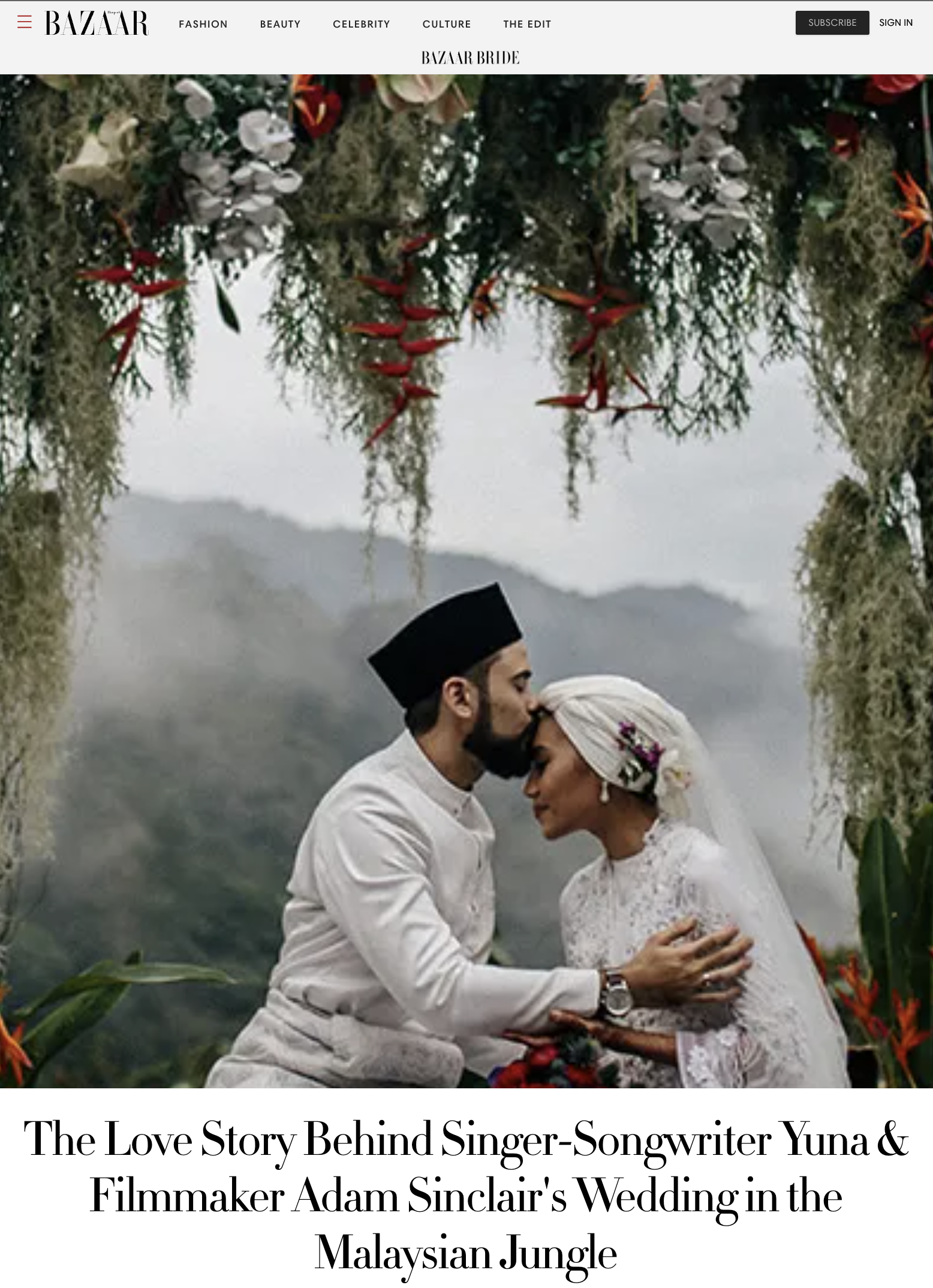 A couple in wedding attire, with the groom wearing a traditional Malay songkok and the bride in a lace dress and headscarf, sharing a tender moment in a lush, foggy Malaysian jungle, framed by hanging flowers and greenery.