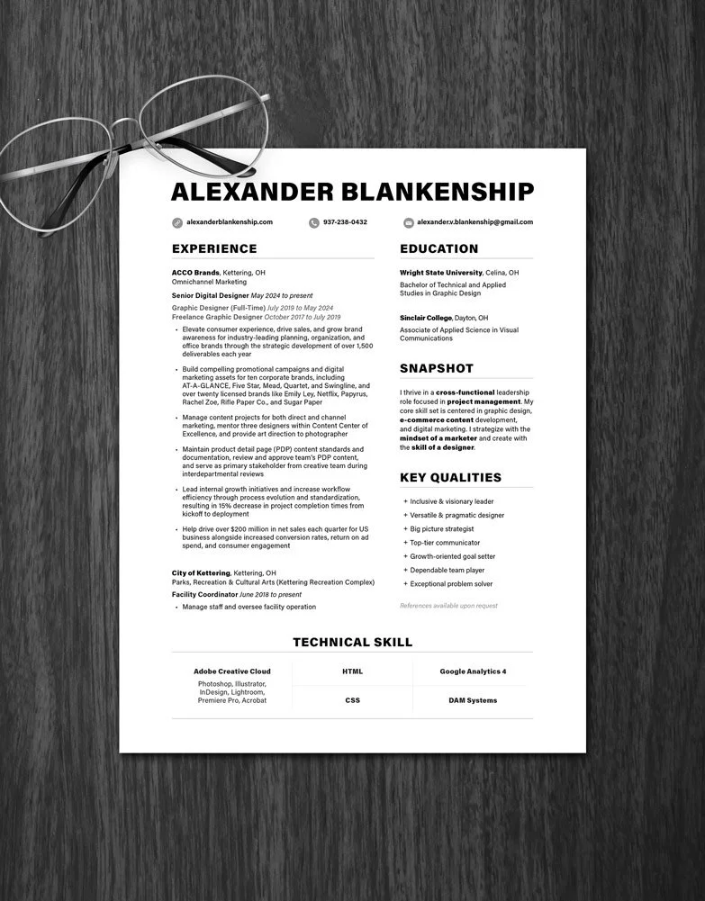 Resume preview on dark wood desk with glasses nearby