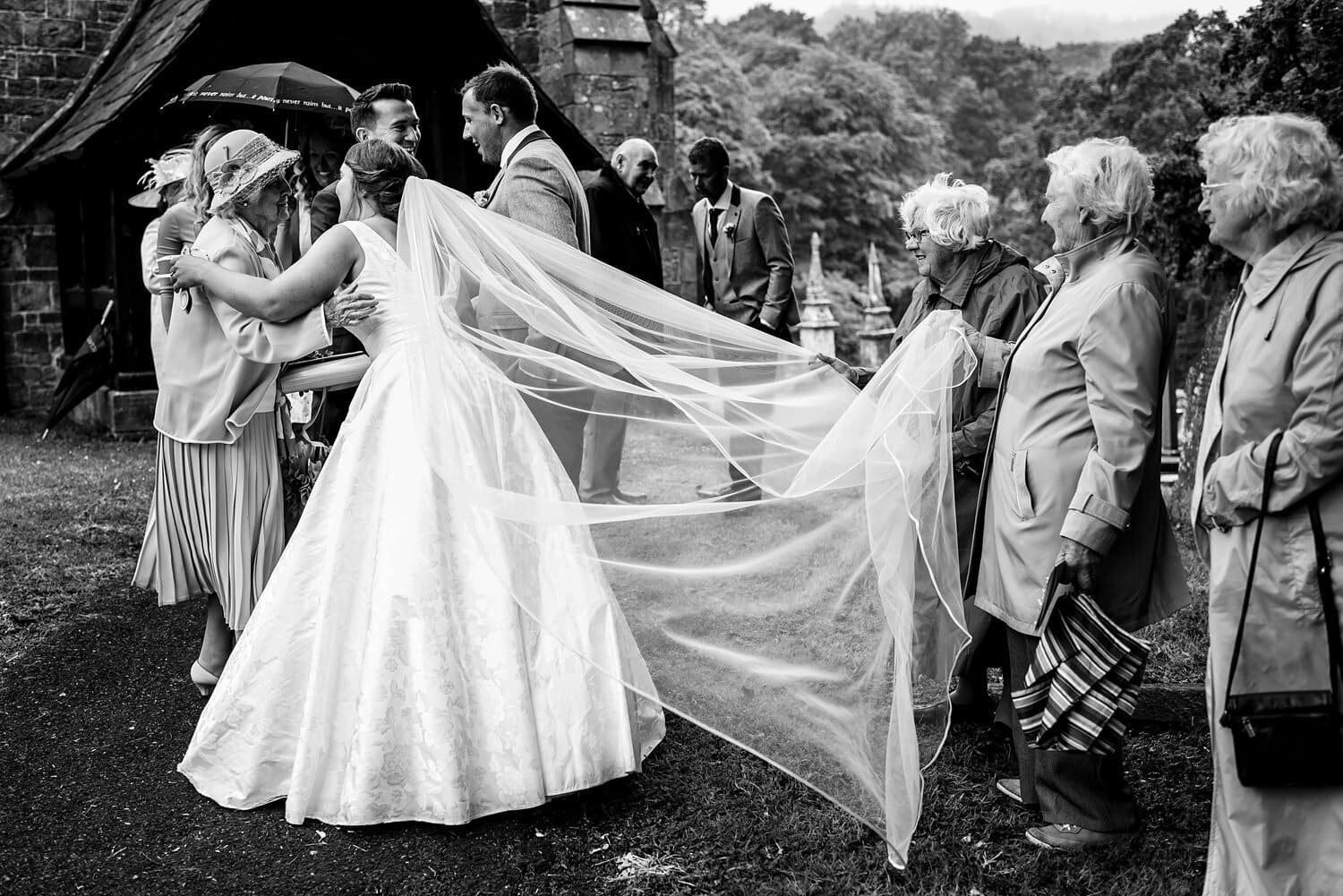 The bride greets wedding guests at Carmarthenshire wedding. Photo by Real and Rich Photography