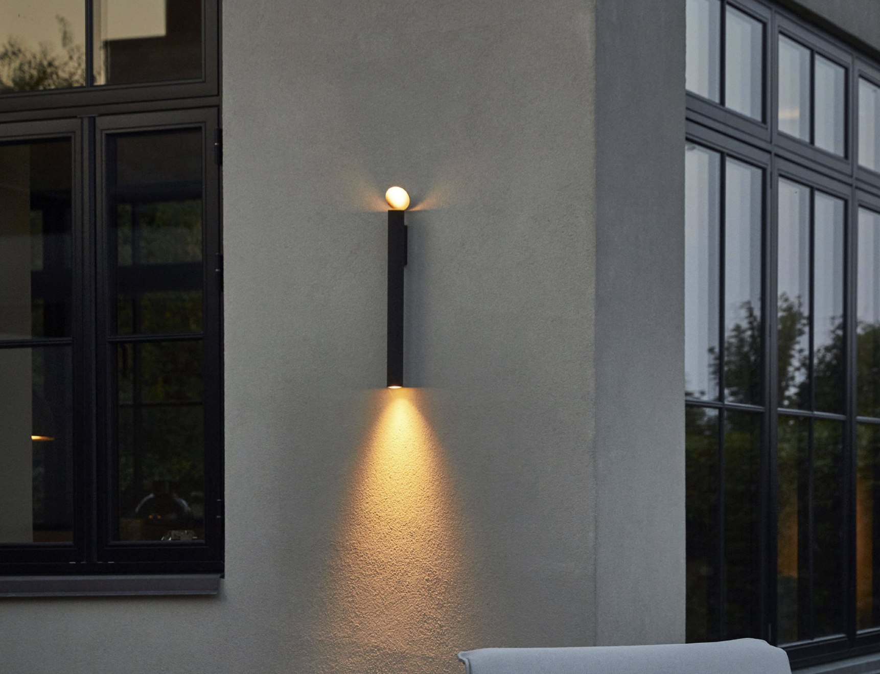 Flauta Spiga 2 Wall Light by Flos with slender minimalist design providing ambient lighting for outdoor terrace or garden.