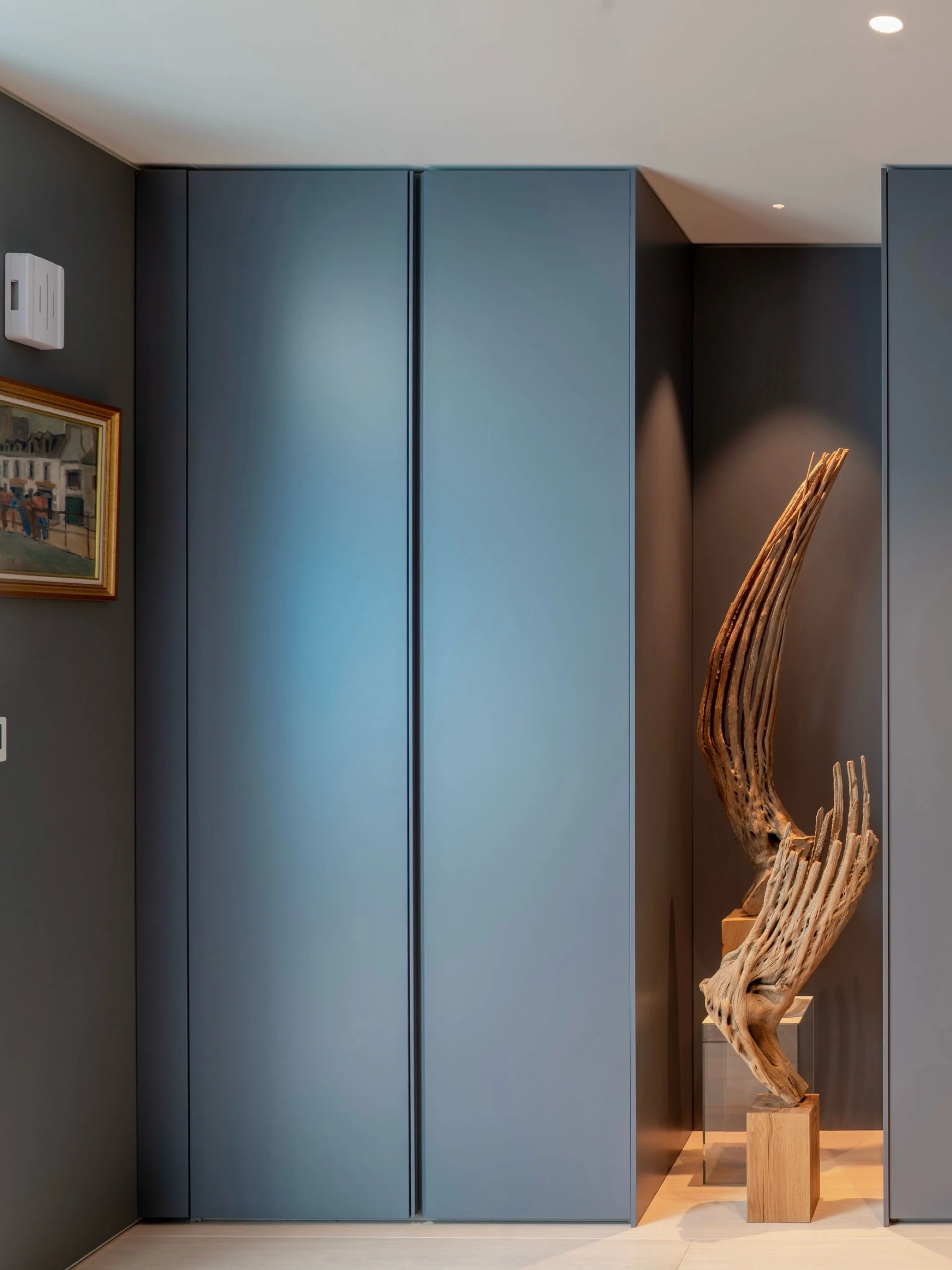 as a continuous architectural wall, these full-height wardrobes maximise functionality while maintaining a clean entrance. Every detail - from the paint finish and shadow gaps to the lighting positions - was carefully coordinated to frame the cactus 