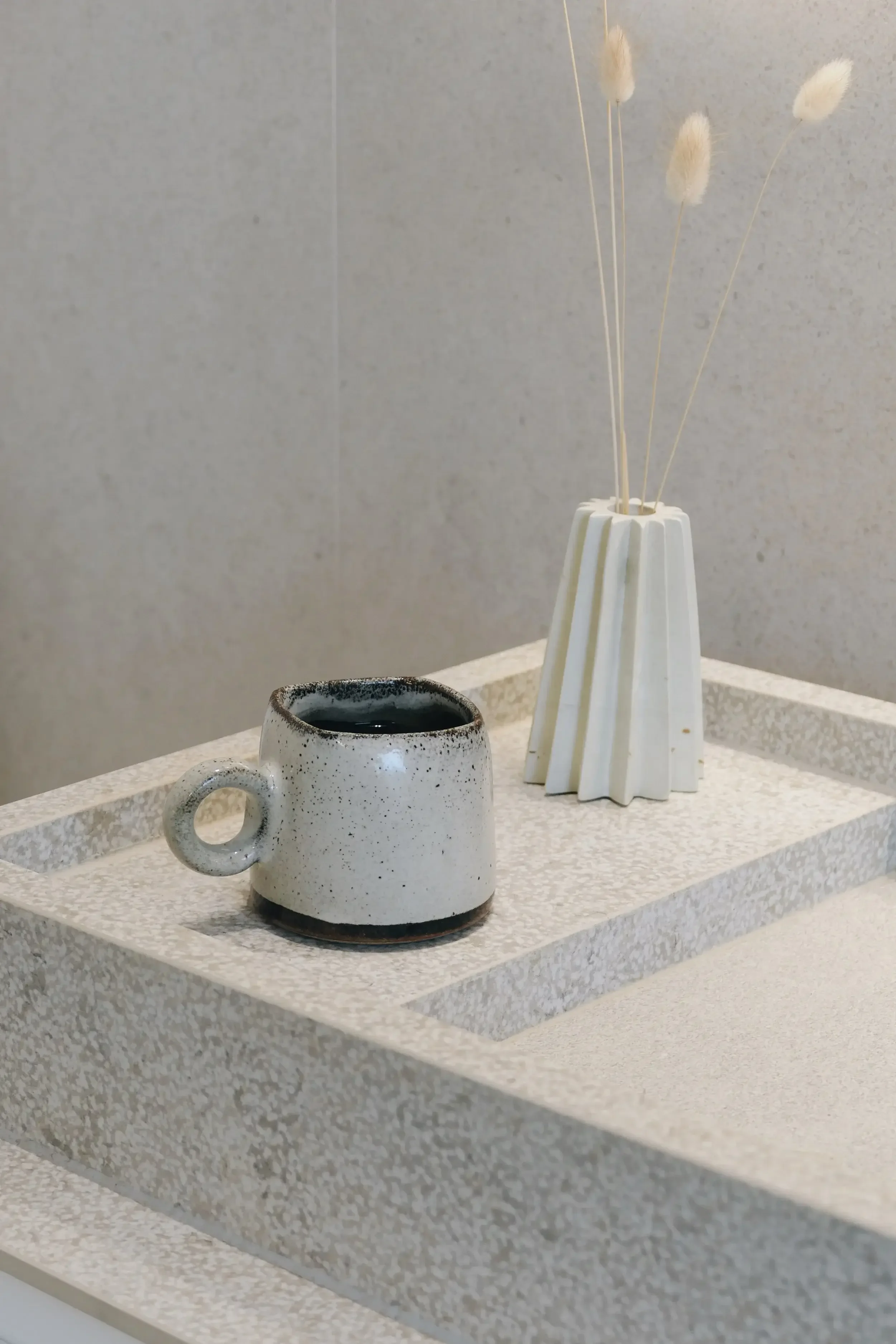 Detail of a poircelain wash basin, set against minimalist porcelain wall tiles.