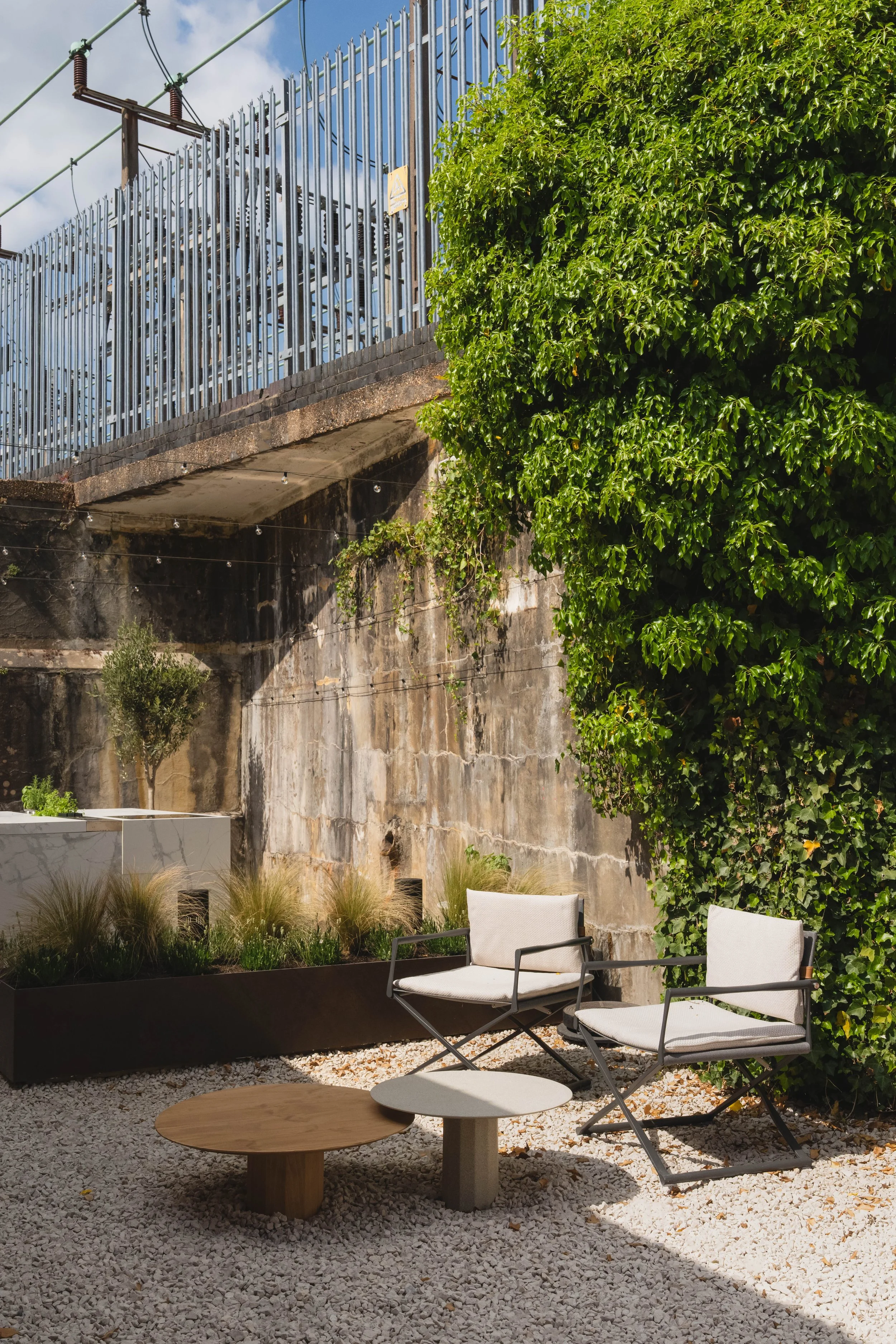 Riviera outdoor chair by Talenti with aluminium frame, leather backrest, and textured cushions in modern outdoor lounge.