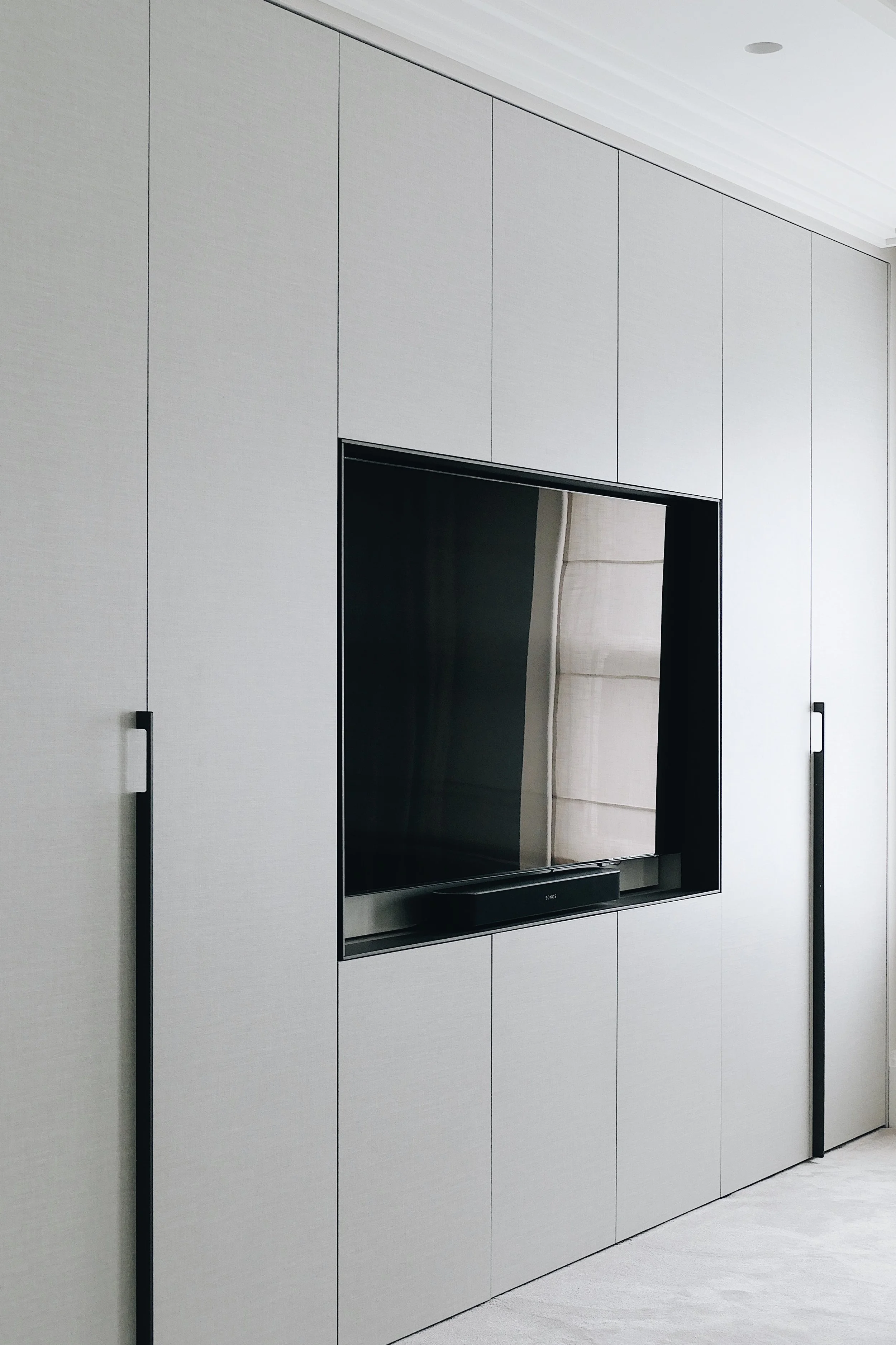 Minimal and clean wardrobe and TV unit designed by Abitalia South Coast in Canford Cliffs