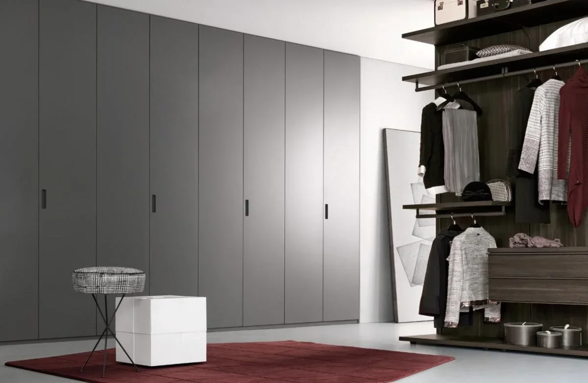 Minimalist bedroom wardrobe with coplanar sliding panels and refined architectural detailing.
