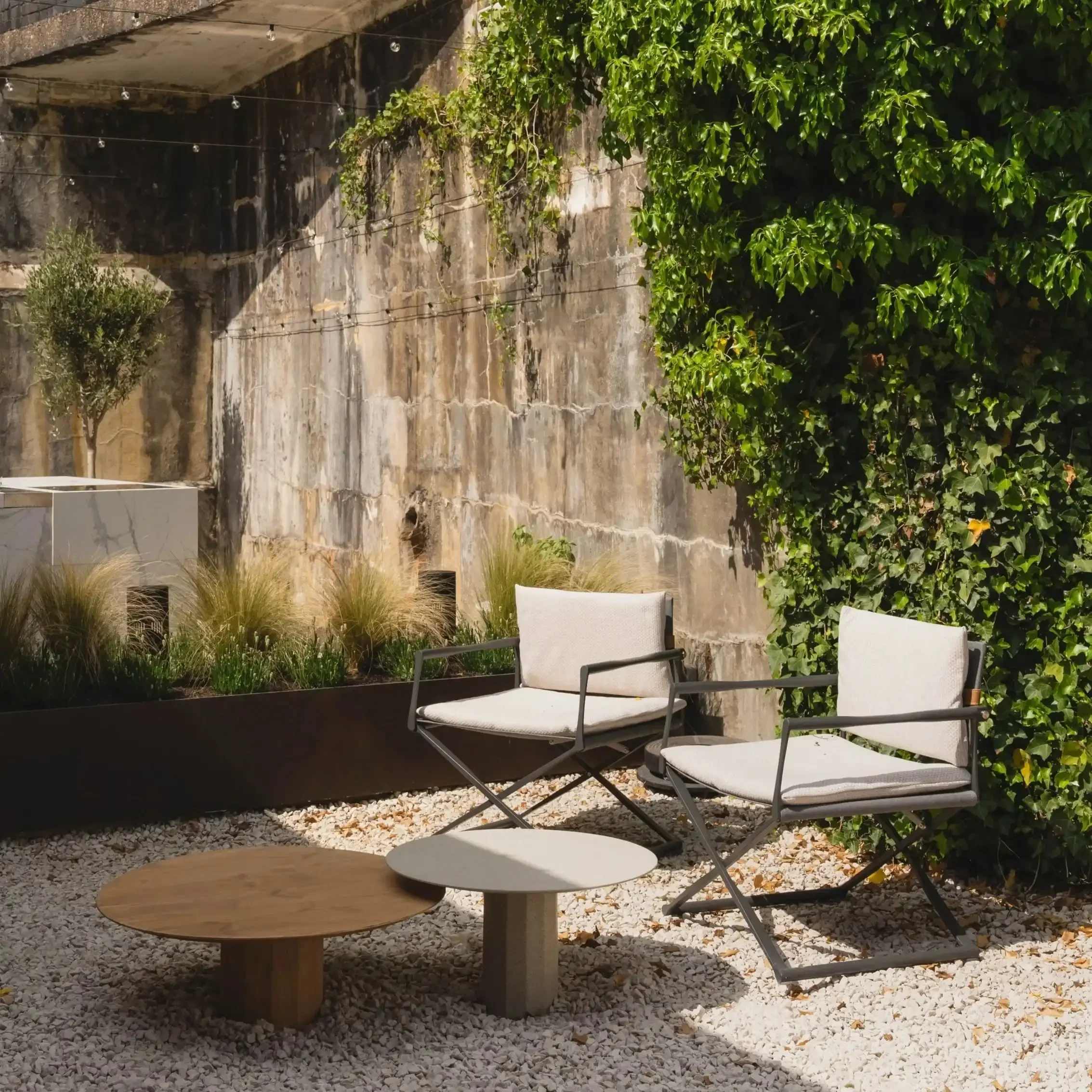 Riviera outdoor chair by Talenti with aluminium frame, leather backrest, and textured cushions in modern outdoor lounge.