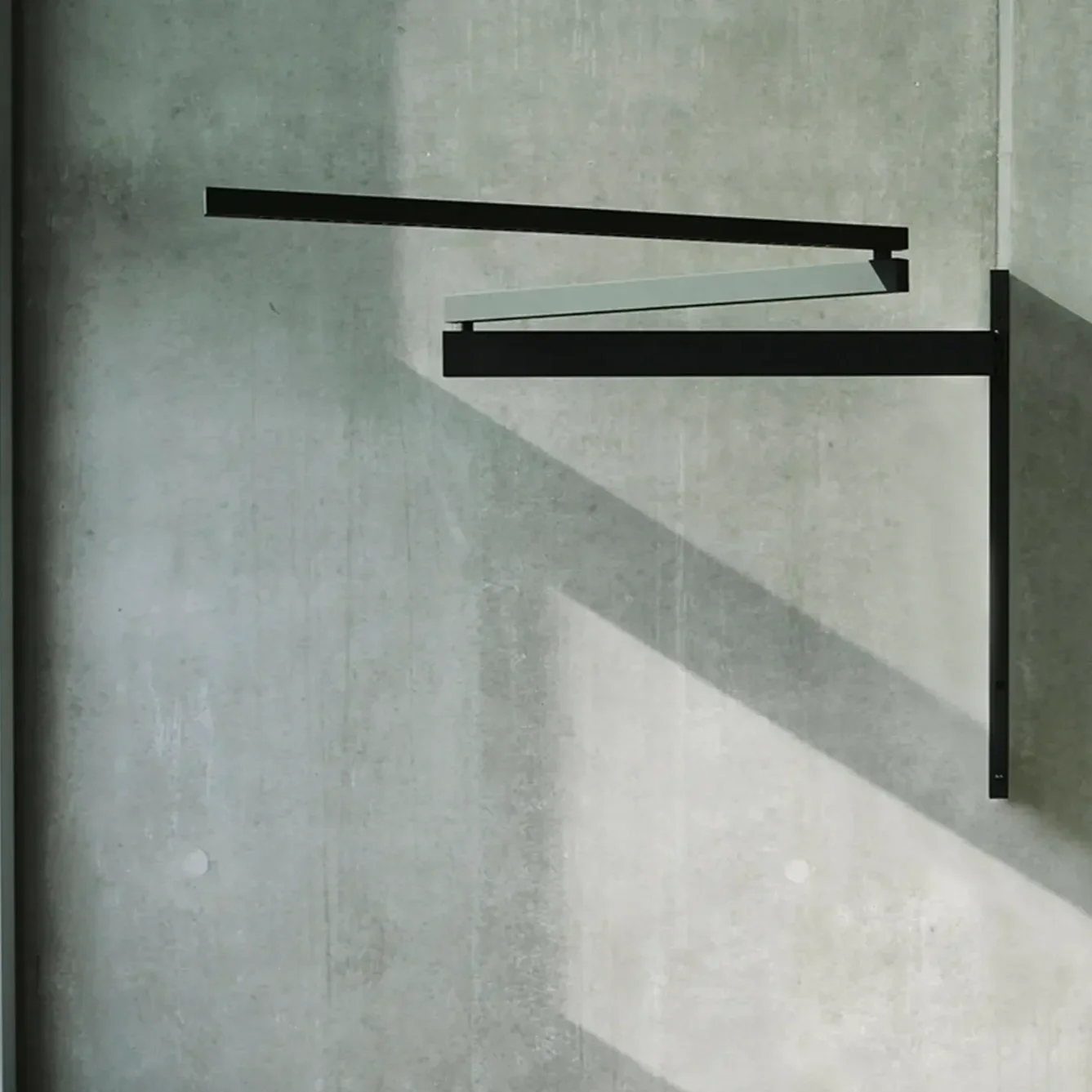 Flos Black Flag wall light mounted with adjustable arm and minimalist design.