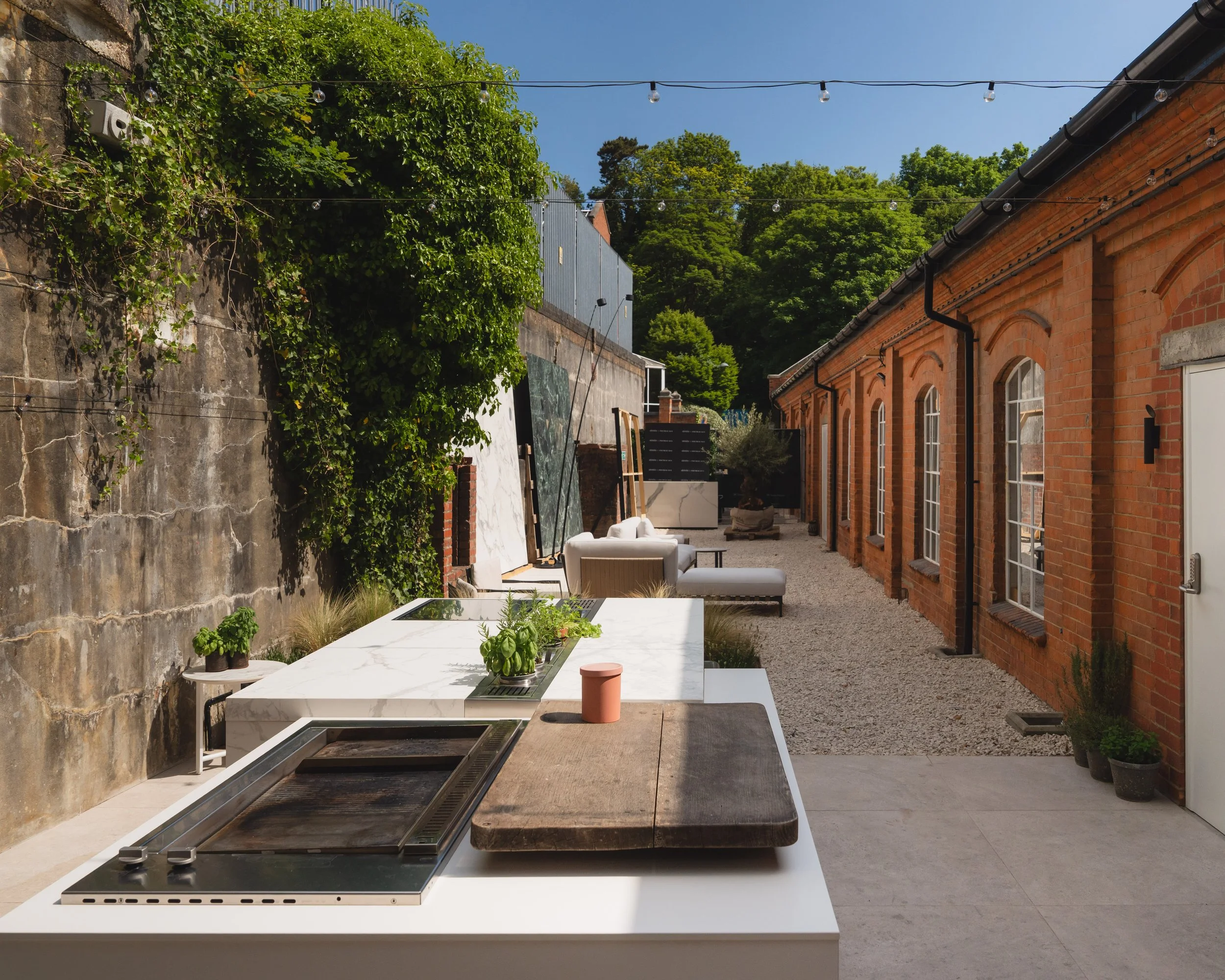 Contemporary outdoor kitchen featuring architectural volumes and natural textures.