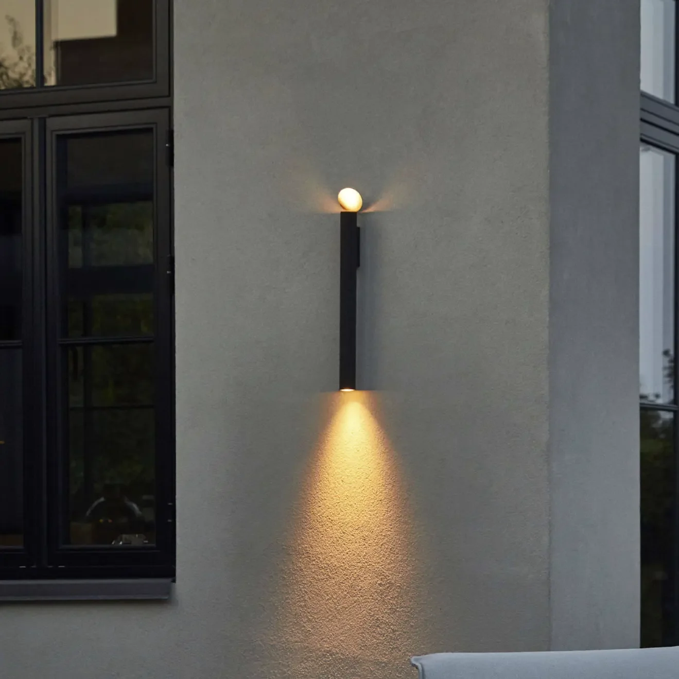 Flauta Spiga 2 Wall Light by Flos with slender minimalist design providing ambient lighting for outdoor terrace or garden.