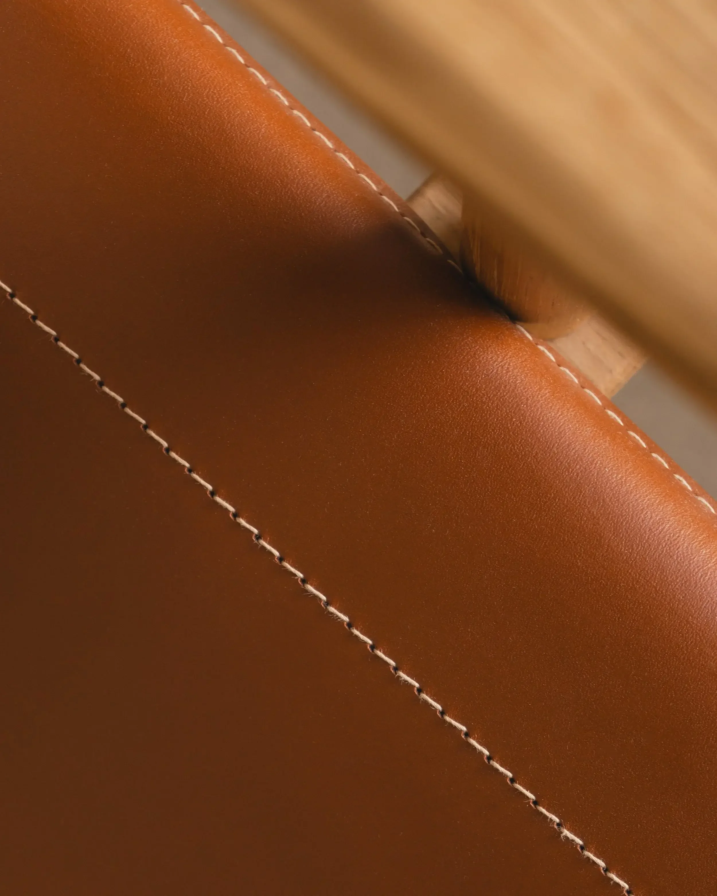 Elegant lounge chair in oak frame with linen or leather upholstery, highlighting Scandinavian craftsmanship.