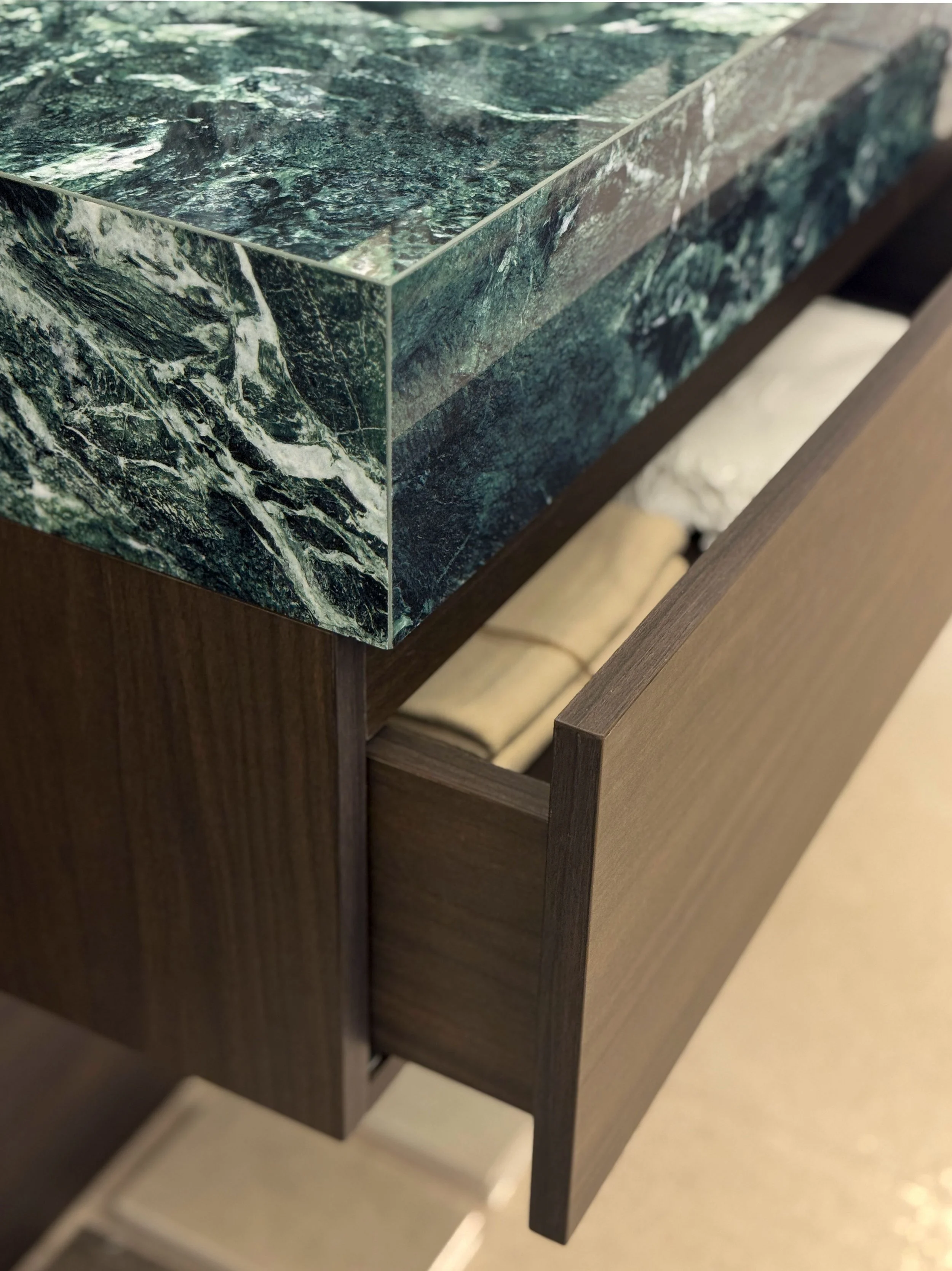 Detail of the Noce oak drawer, emphasizing warm texture and high-quality craftsmanship.