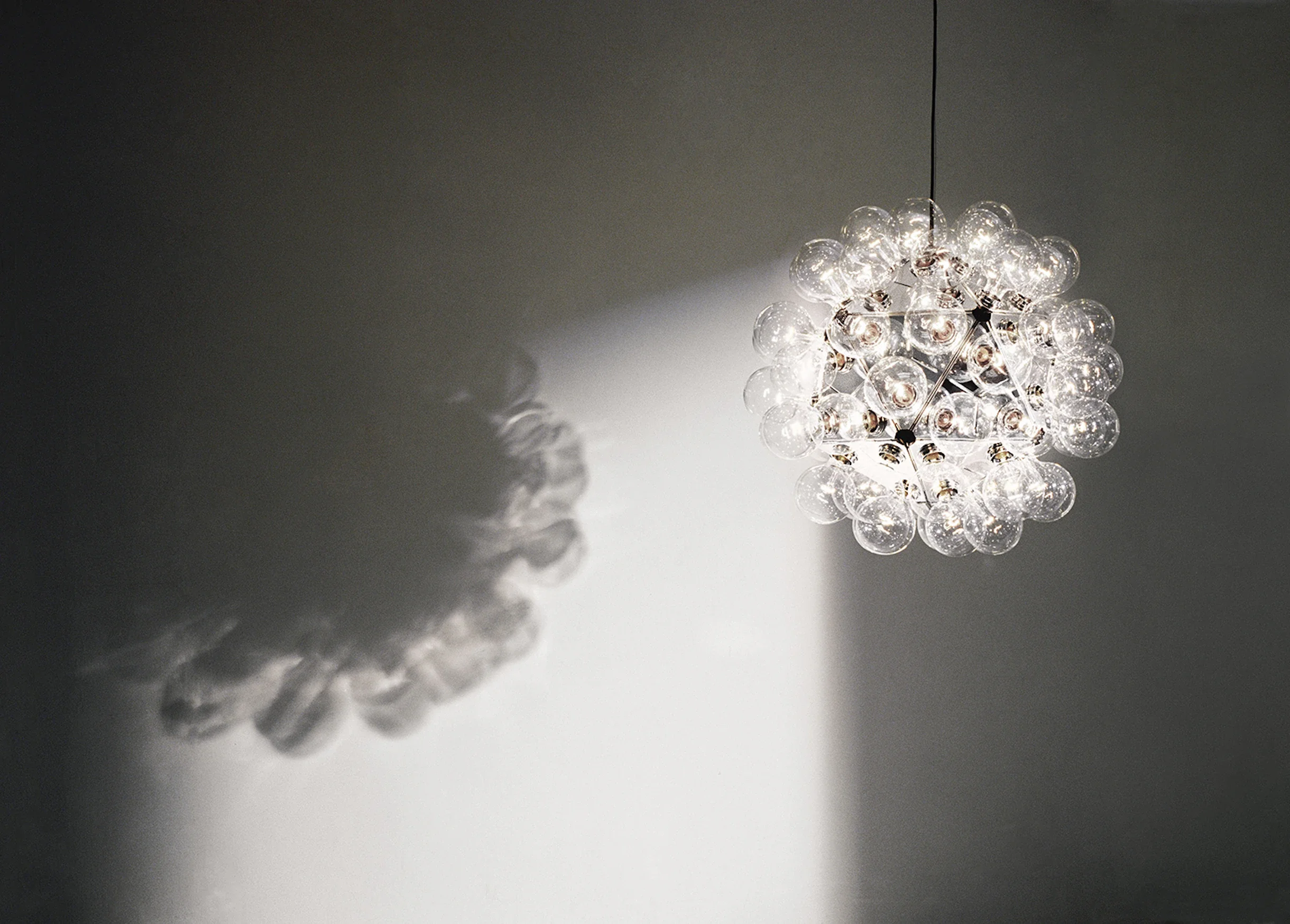 Taraxacum 88 illuminated, demonstrating how the chandelier distributes soft, diffused light while maintaining a bold architectural presence.