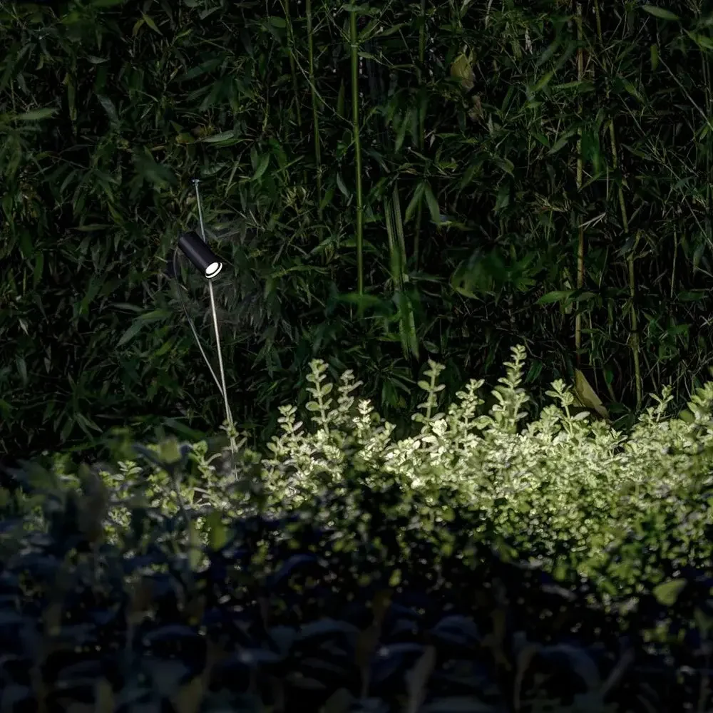 Davide Groppi Grillo Outdoor Floor Lamp featuring a matte black adjustable LED projector on a slender stainless steel stem, IP67 rated, supplied by Abitalia South Coast in Dorset, Hampshire, and Surrey.