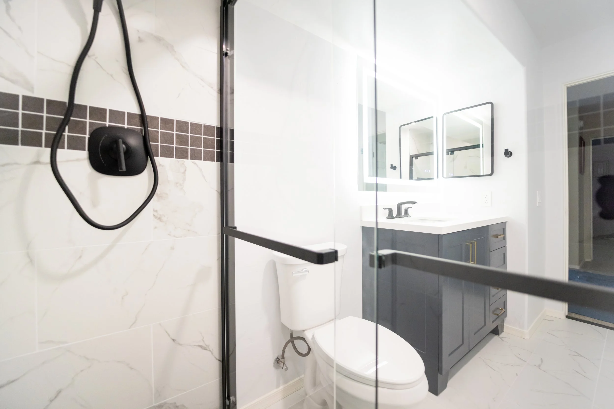 This floor to ceiling bathroom renovation includes shower tile and bathroom floor tile installation, new shower pan, shower door, shower fixtures and vent, light plumbing work and toilet installation, new bathroom cabinet and sink, as well as medicin