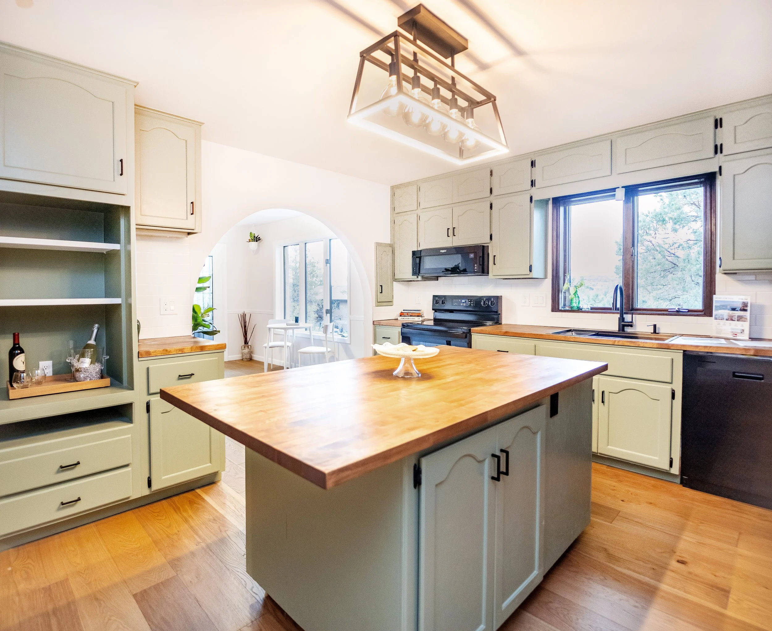 A complete kitchen renovation.  This remodel project included interior and exterior kitchen cabinet painting with modern drawer pulls and handles, new flooring and baseboards, new backsplash tile installation and butcher block countertops, and modern