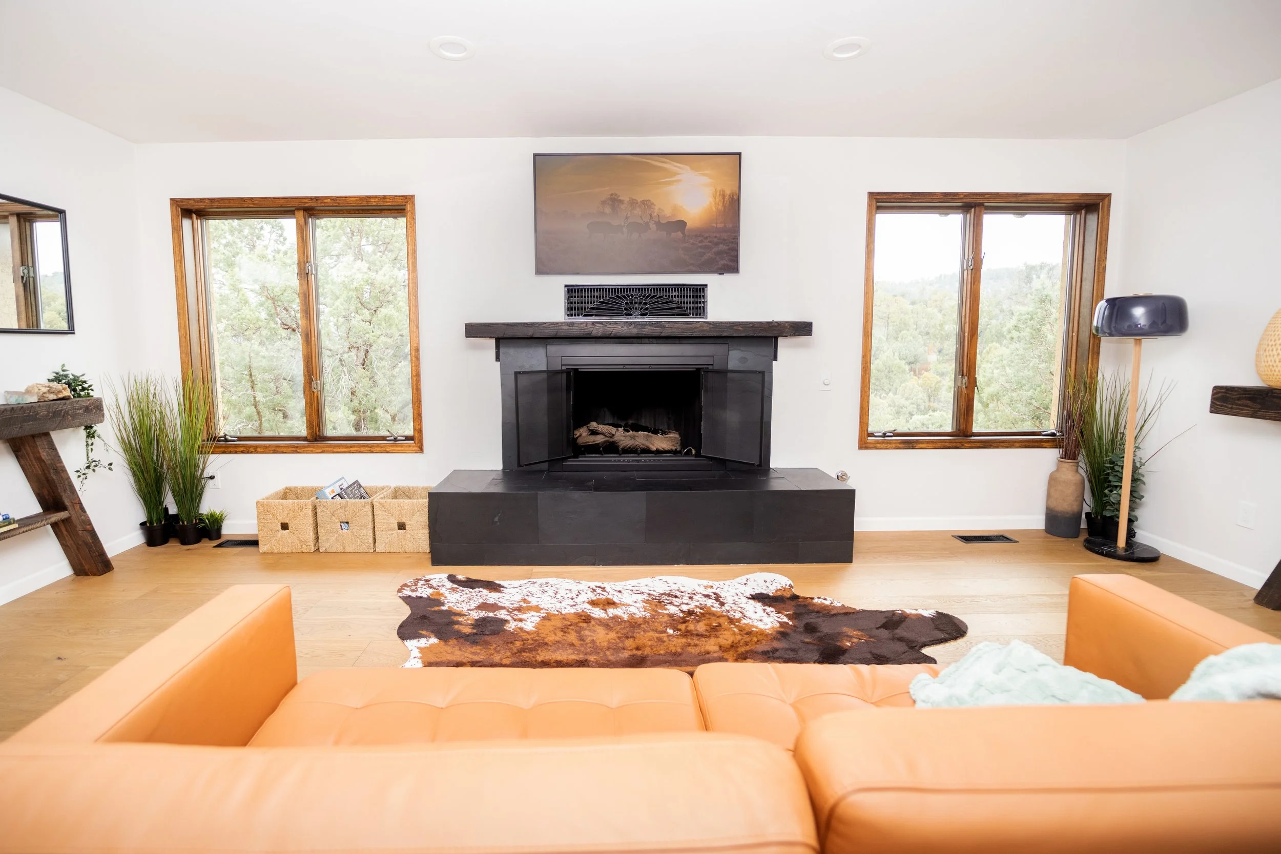 The living room remodel started with the engineered flooring installation, and new baseboards, then cleaning and staining of all doors and window trim.  Sleek black slate tile with black grout was added modernize the fireplace.  