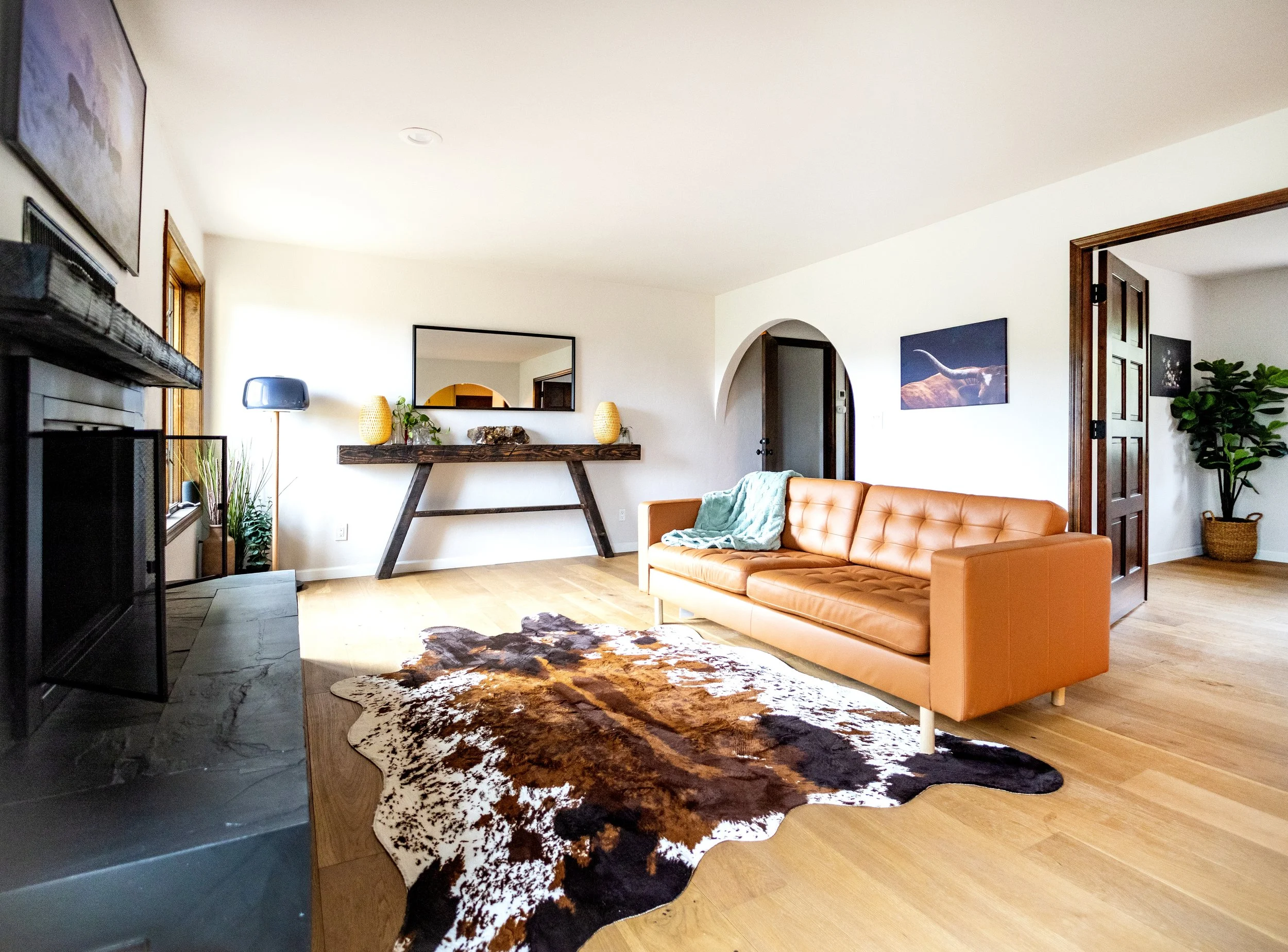 The living room remodel started with the engineered flooring installation and new baseboards, then cleaning and staining of all doors and window trim.  Sleek black slate tile with black grout was added modernize the fireplace.  