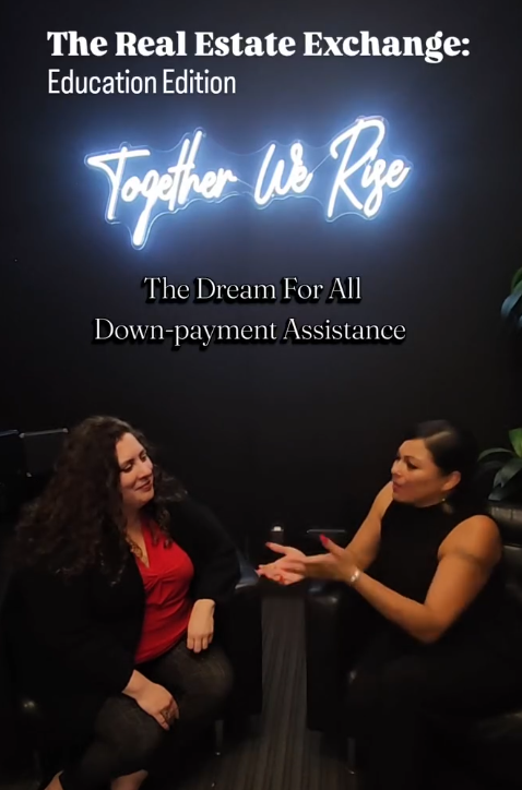 Two women sitting and talking in front of a sign that reads 'The Real Estate Exchange: Education Edition. Together We Rise. The Dream For All Down-payment Assistance.'