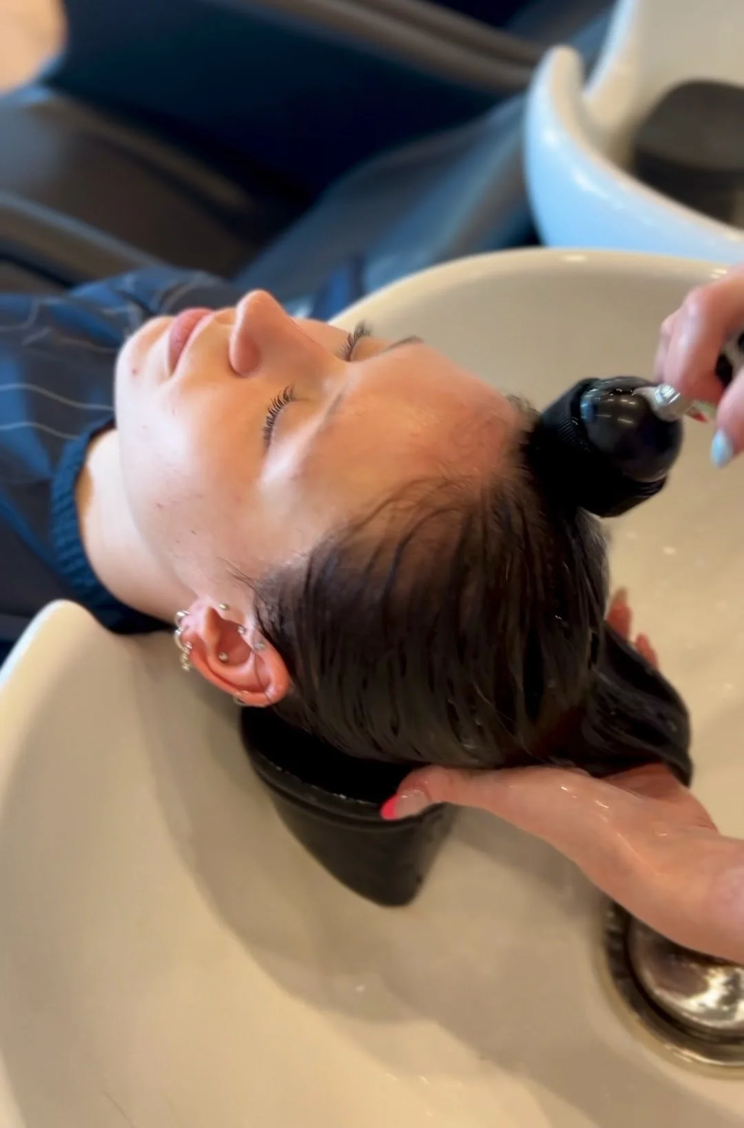 Client having hair shampooed at a basin