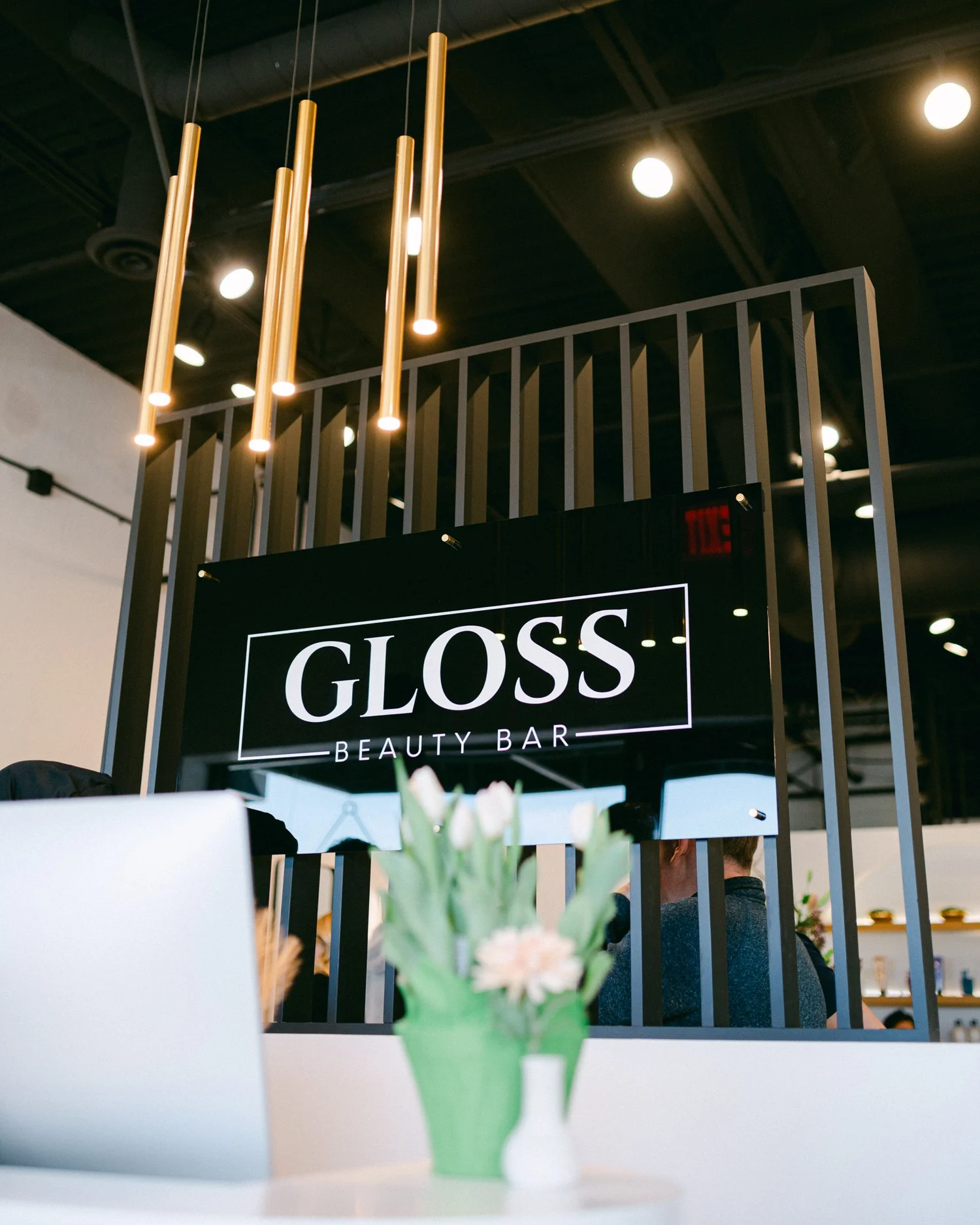 Gloss Beauty Bar sign with pendant lights in the salon