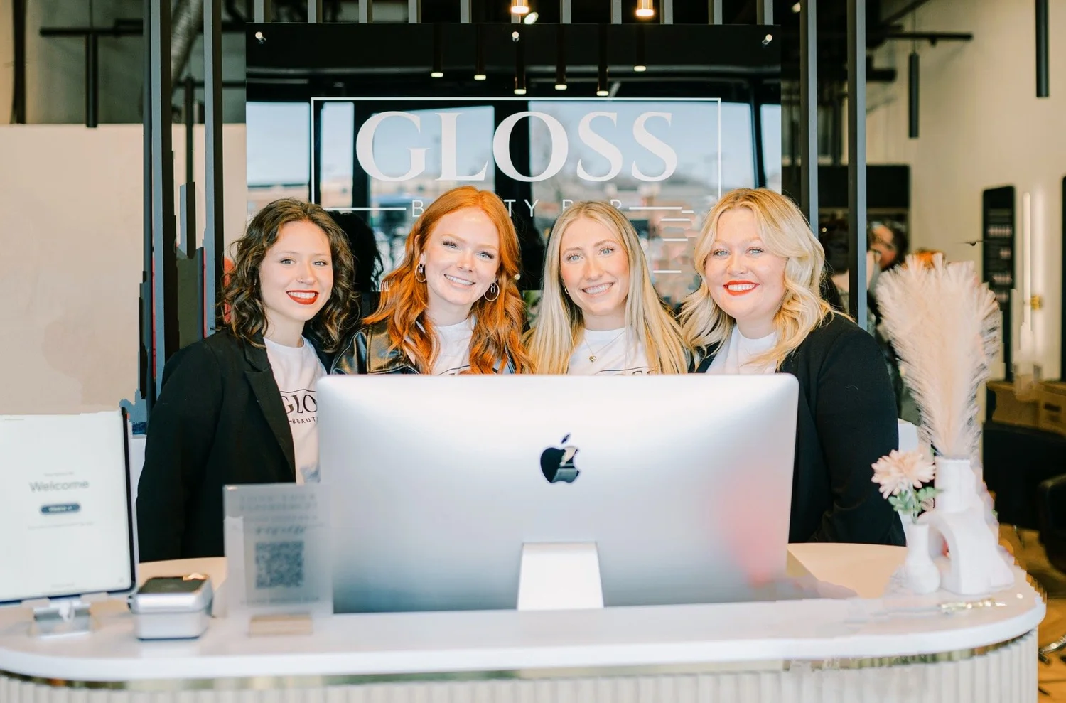 Four staff members smiling at the front reception desk