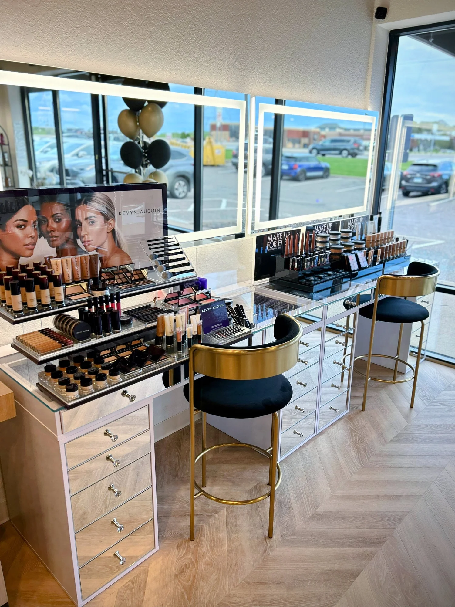 Makeup counter with mirrors, gold stools and product displays